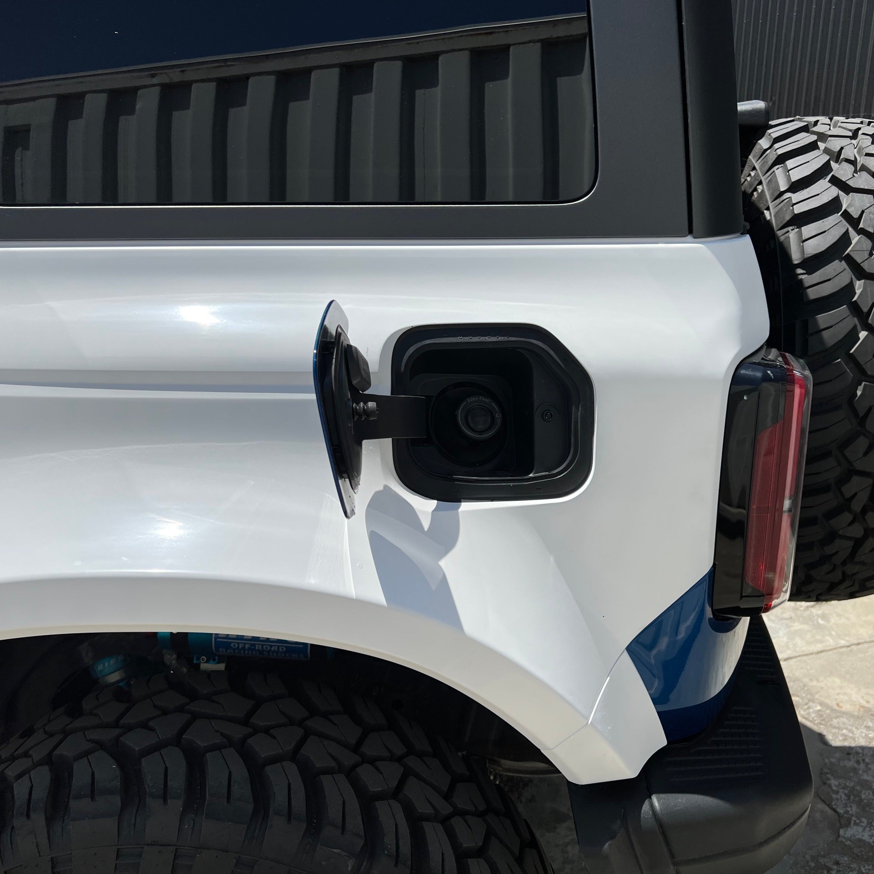 2021-2025 Ford Bronco 4-Door Rear Quarter Kit showcasing the rear fuel door and tire on a white vehicle.