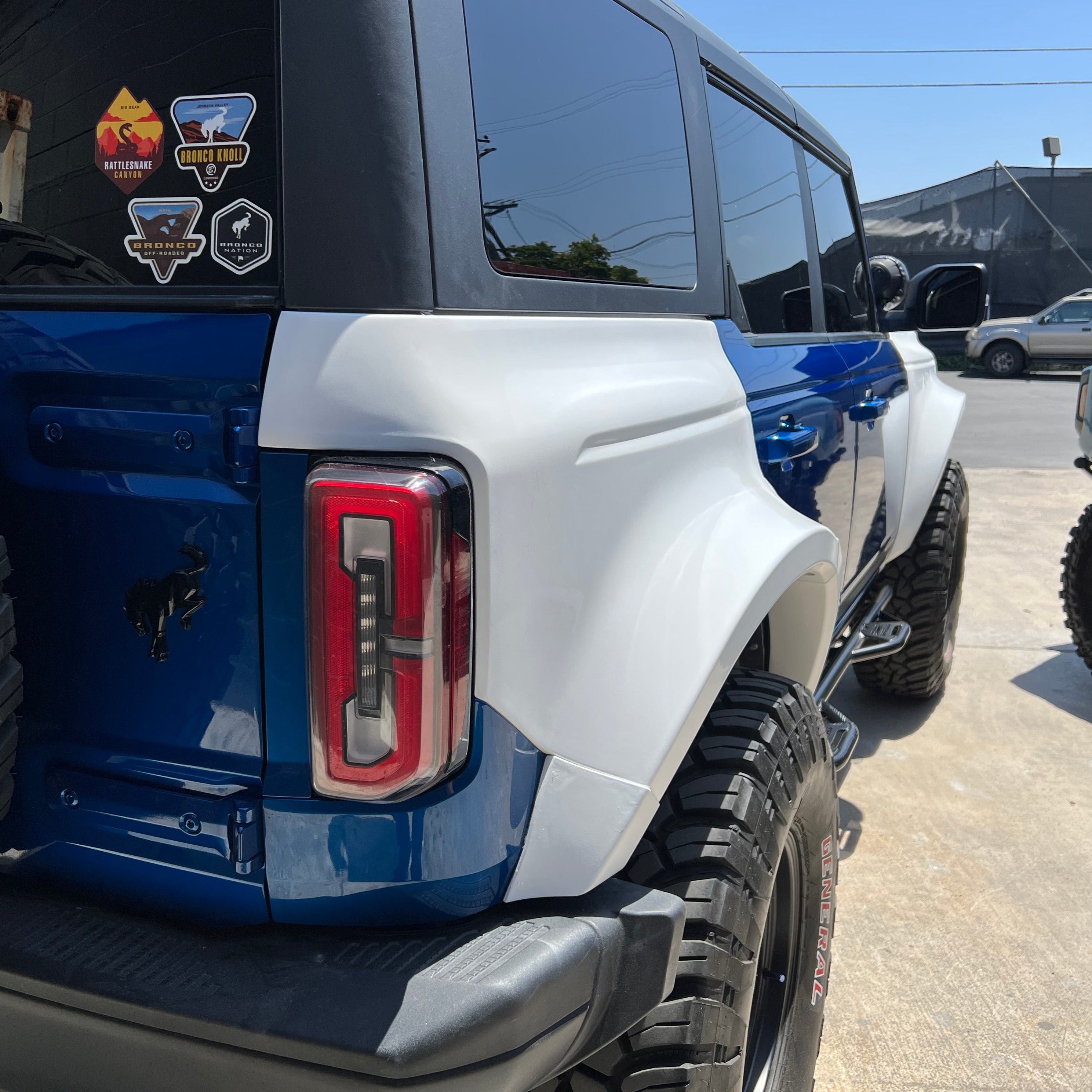 2021-2025 Ford Bronco 4-Door Rear Quarter Kit installed on a blue Bronco, showcasing enhanced off-road styling and durability.