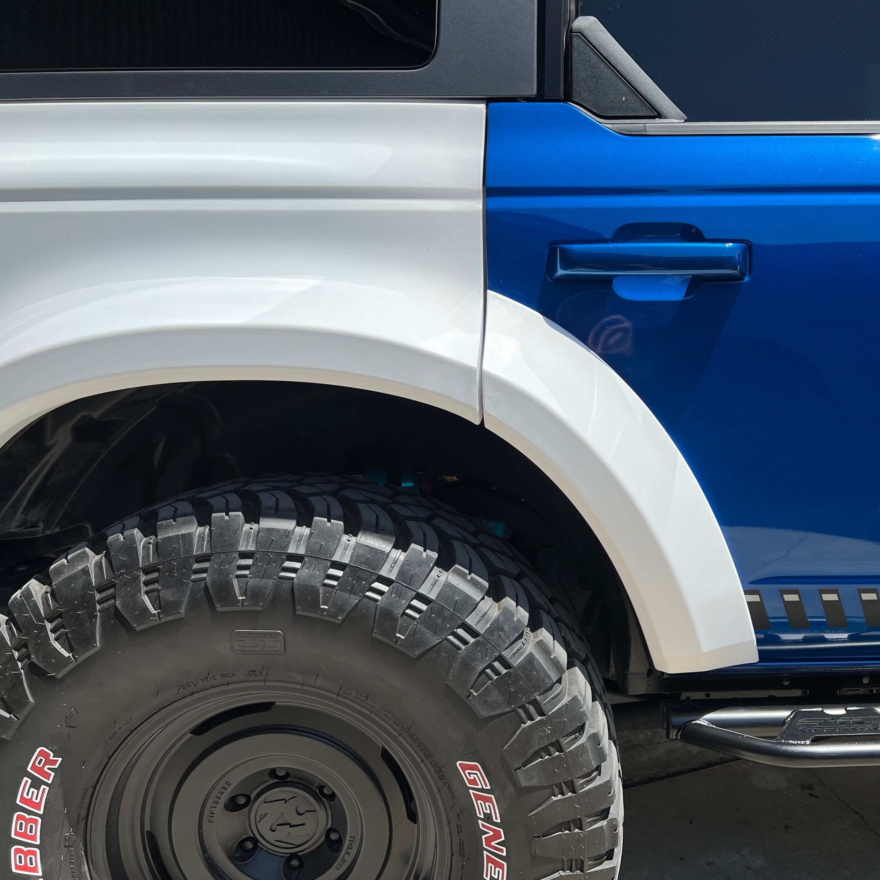 2021-2025 Ford Bronco 4-Door Rear Quarter Kit showcasing a blue vehicle with a white fender flare and rugged tire.