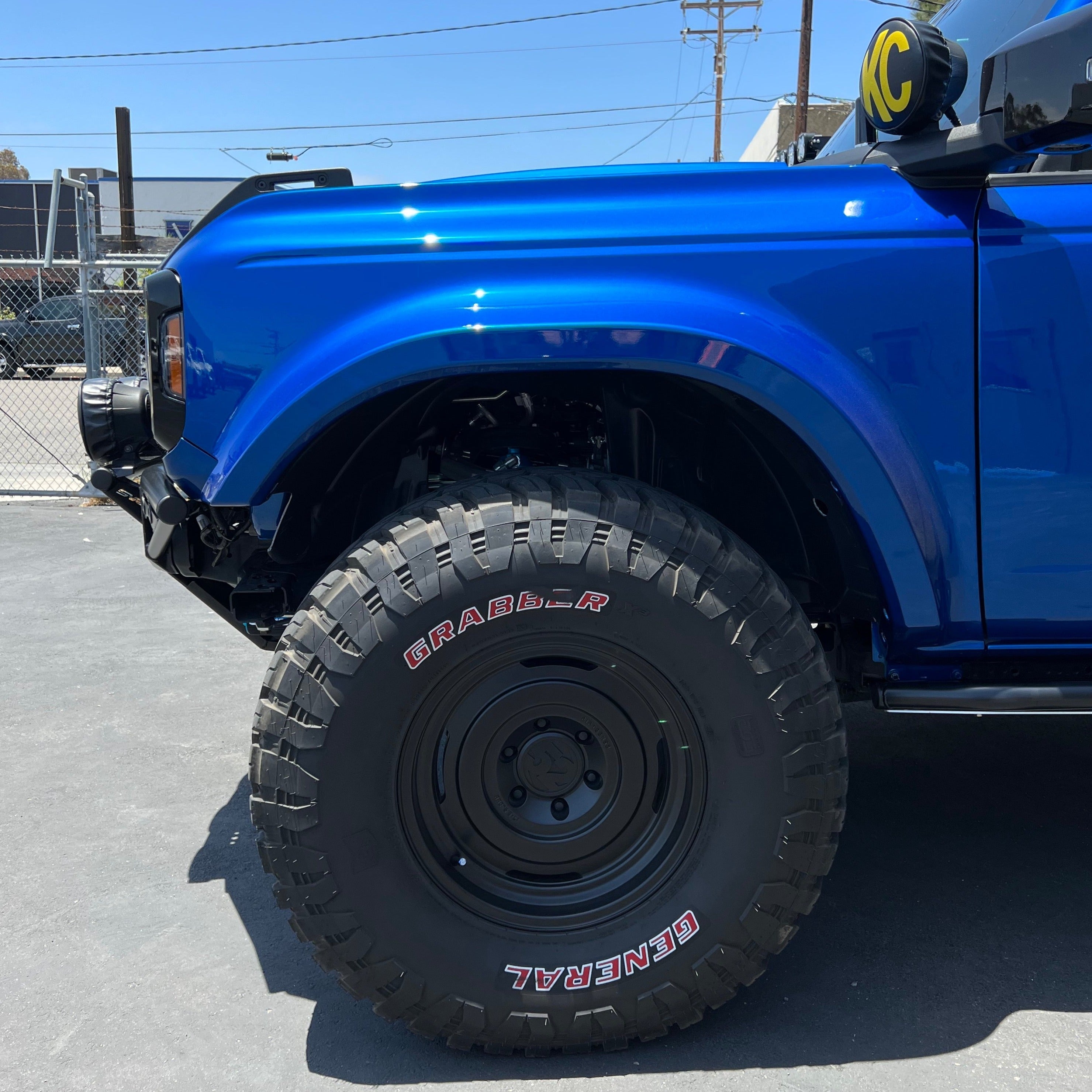 2021-2022 Ford Bronco fenders showcasing a blue exterior and rugged offroad tires, highlighting durability and style.