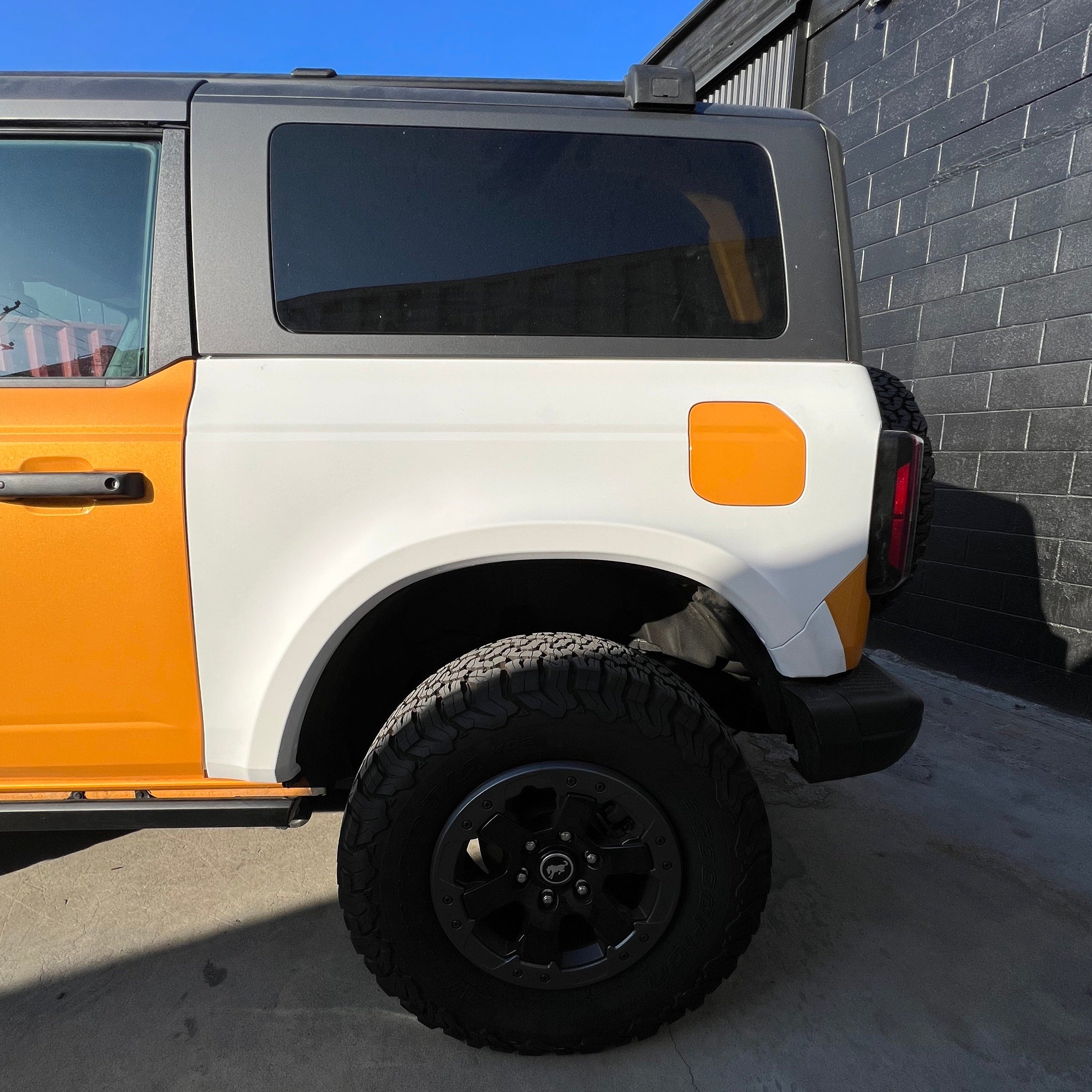 2021-2025 Ford Bronco 2-Door Rear Quarter Kit showcasing a rugged design with a black wheel and bold orange and white color scheme.