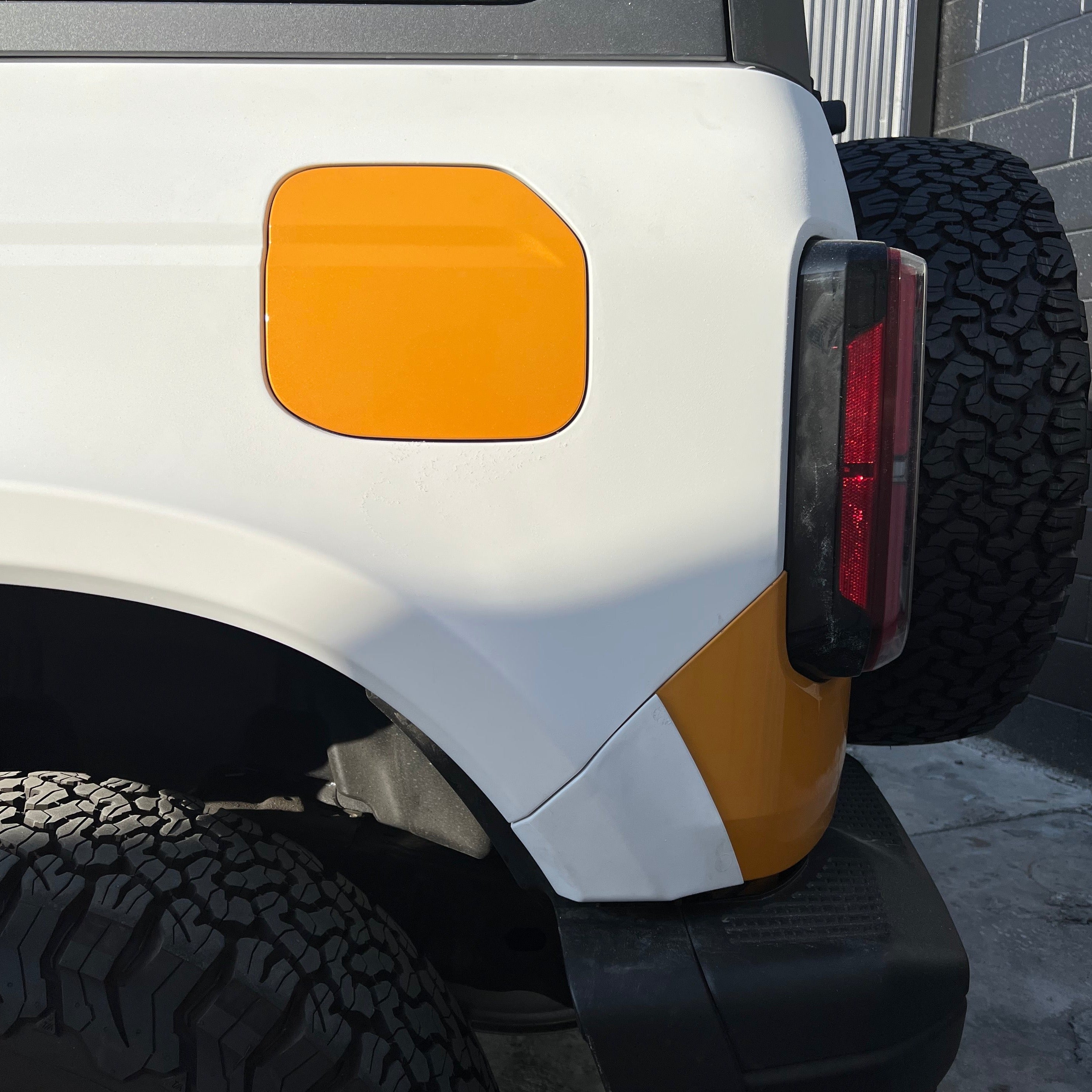2021-2025 Ford Bronco 2-Door Rear Quarter Kit showcasing a white and orange rear panel with a tire in the background.