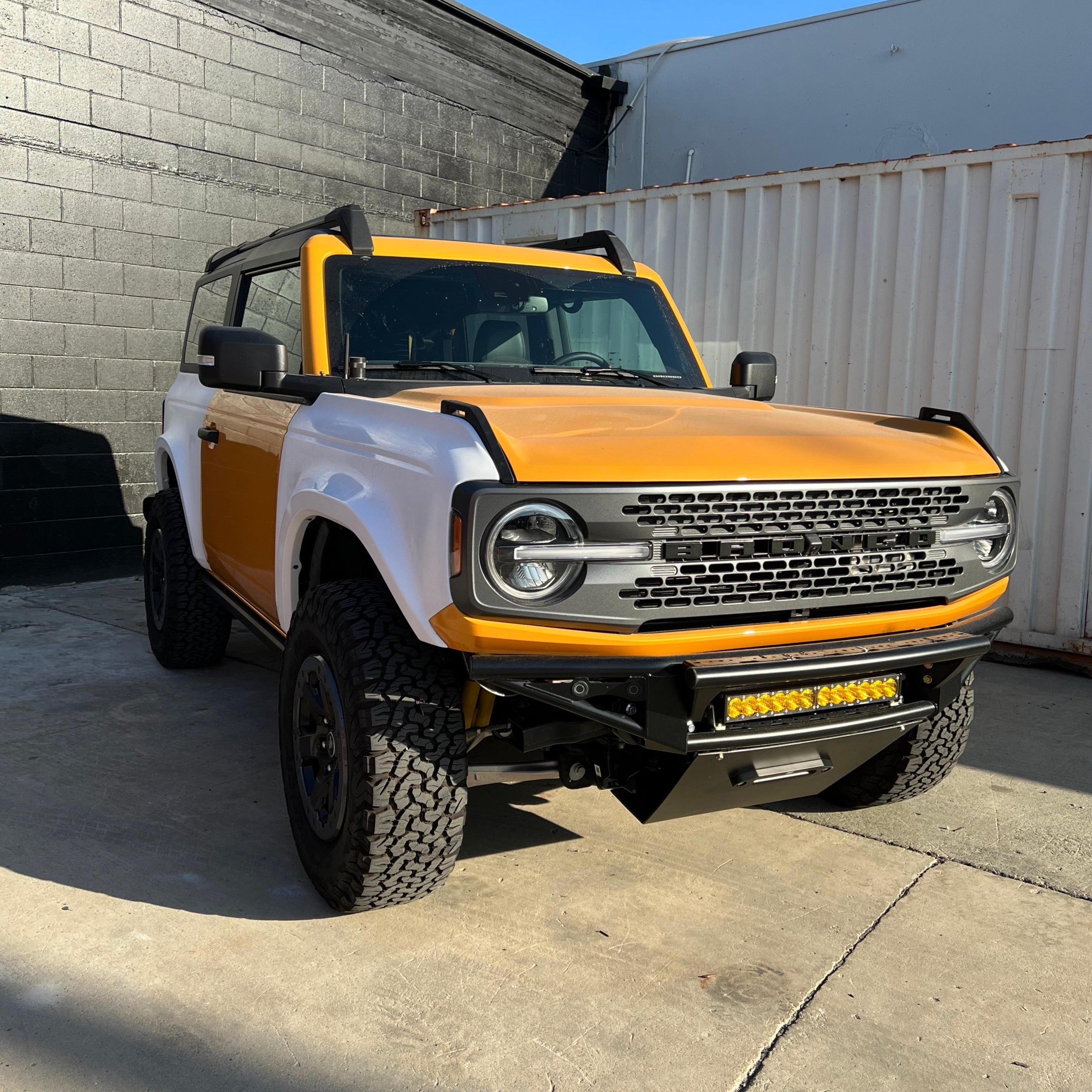 2021-2025 Ford Bronco 2-Door with a custom rear quarter kit, showcasing a bold orange and white design.