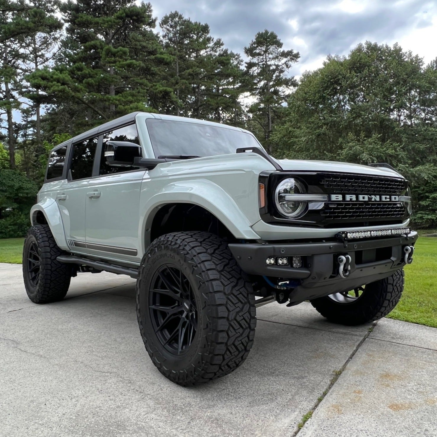 2021-2025 Ford Bronco with custom fenders, showcasing an aggressive offroad design and rugged tires in a natural setting.