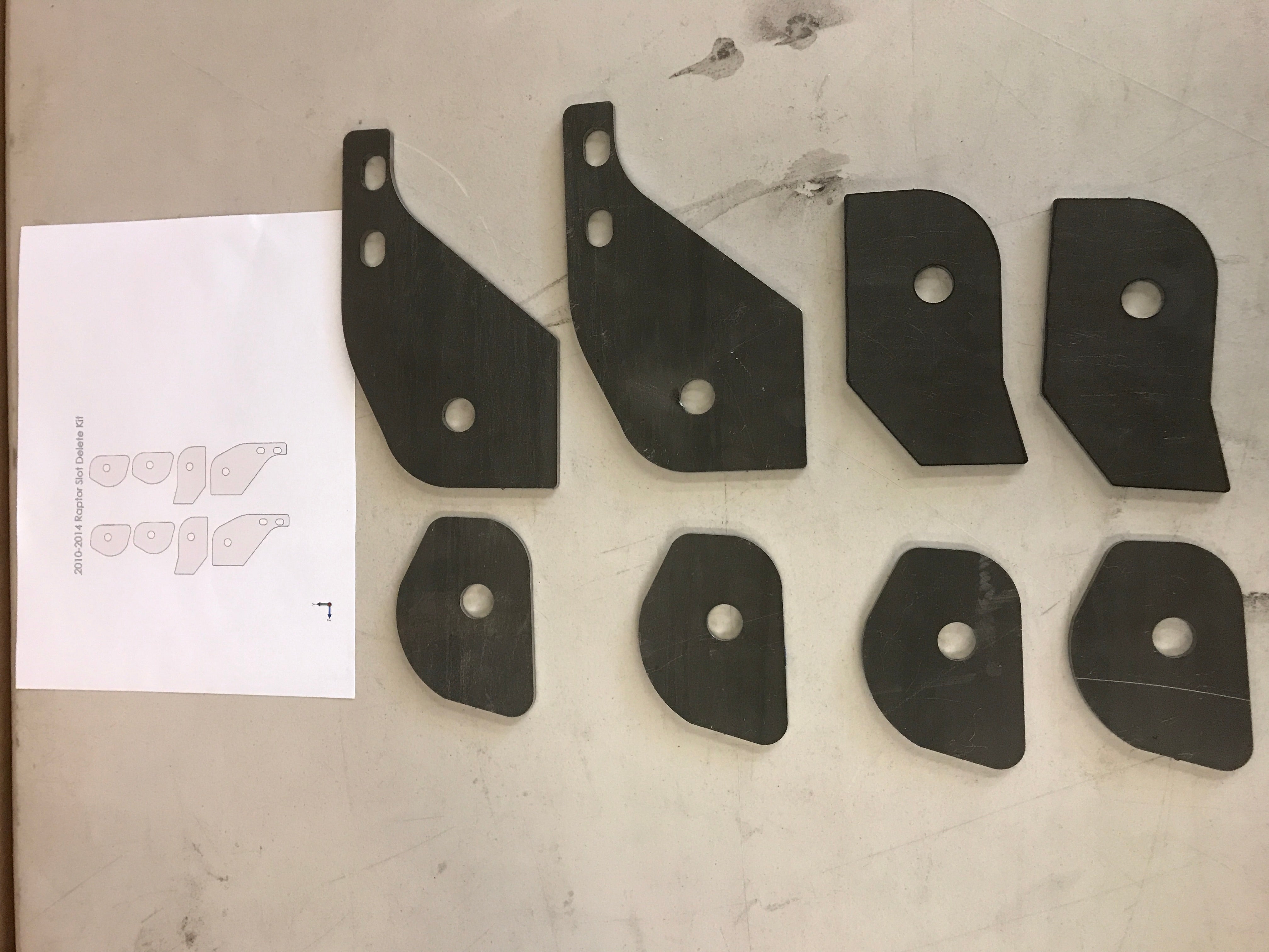 Weld-in plate kit for 2010-2014 Raptor lower arm slot delete, includes multiple plates for installation.