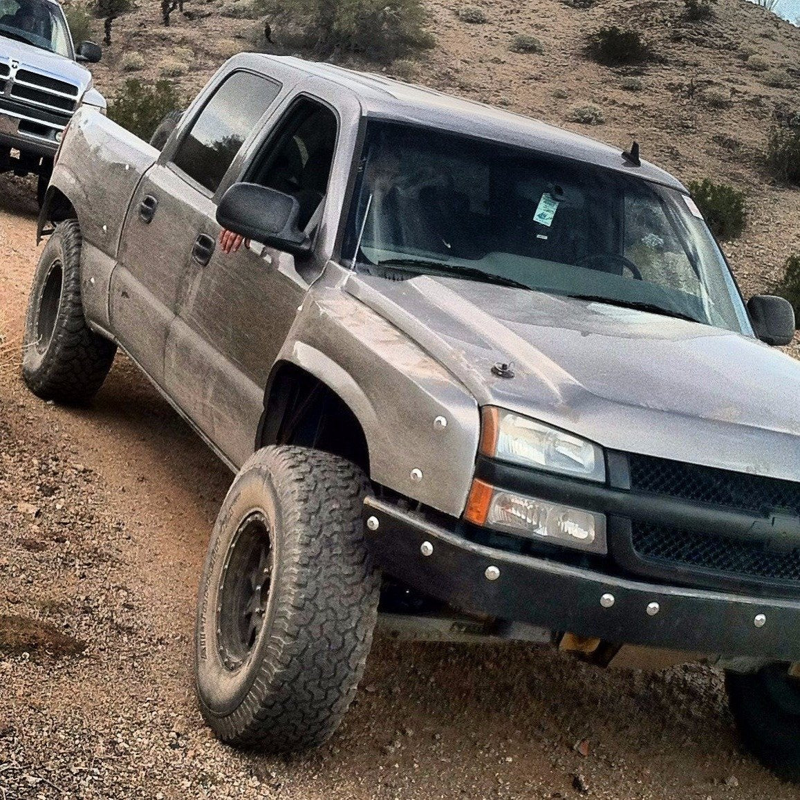 2003-2006 Chevrolet Silverado fenders installed on a modified truck, showcasing off-road capabilities in a rugged terrain.