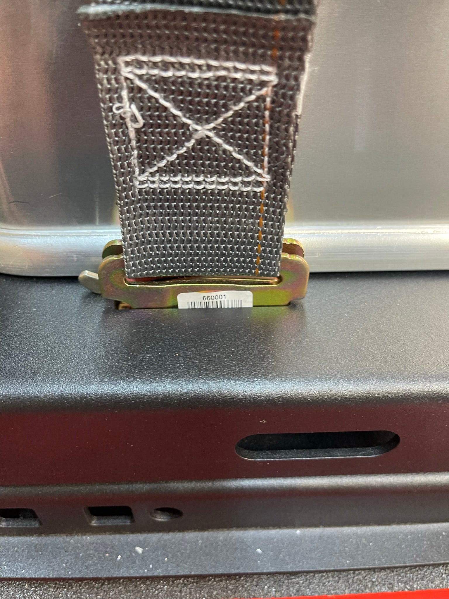 Close-up of a strap and buckle on the 2017-2024 Raptor Rear Bed Organizer, showcasing its durable design for cargo management.