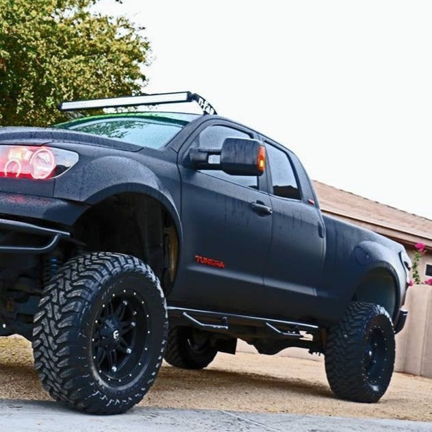 2007-2013 Toyota Tundra with custom bedsides, lifted suspension, and off-road tires parked outdoors.