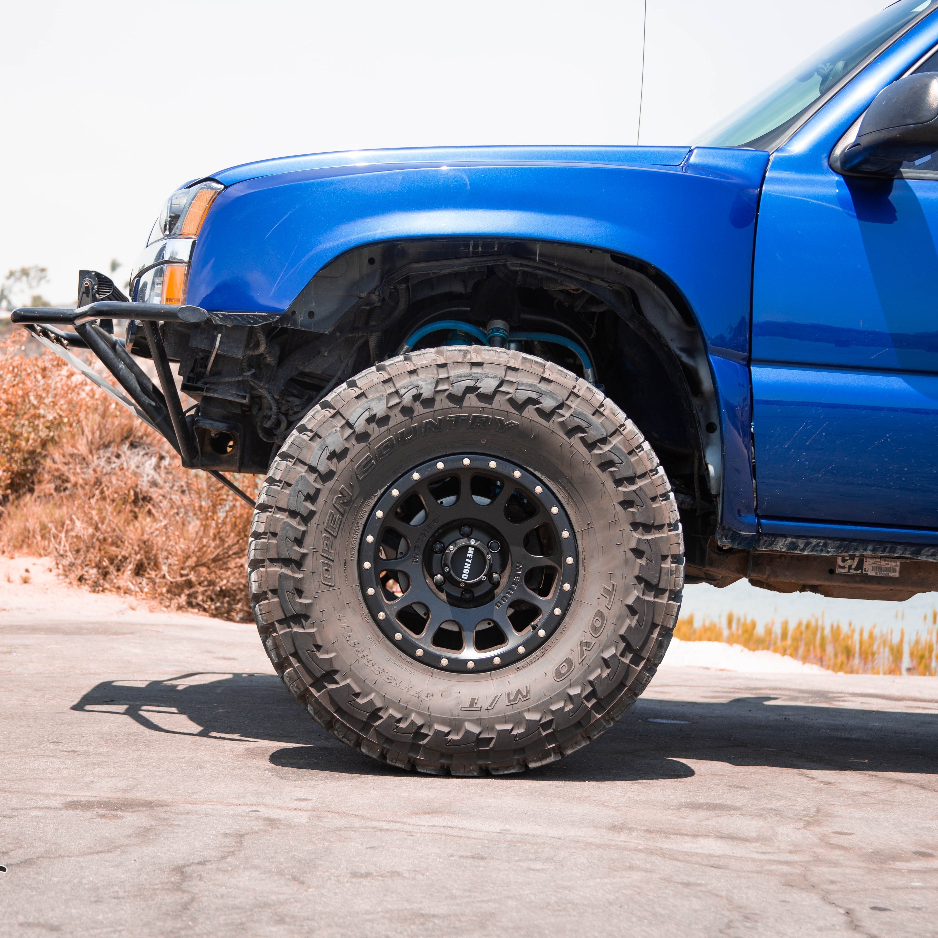 2003-2006 Chevrolet Silverado fenders showcased on a lifted blue truck with large off-road tires.