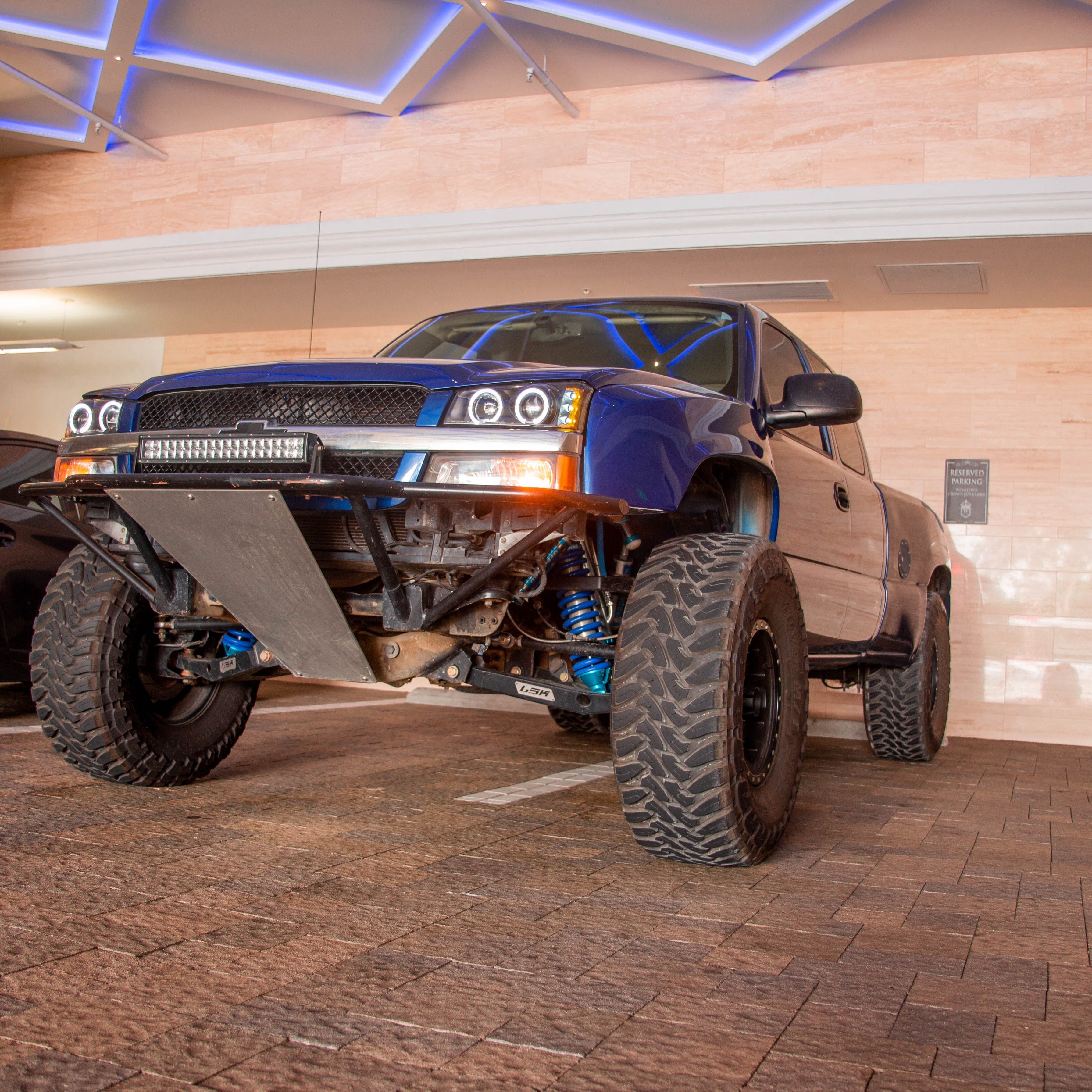 2003-2006 Chevrolet Silverado fenders displayed on a lifted truck with offroad tires in a modern setting.
