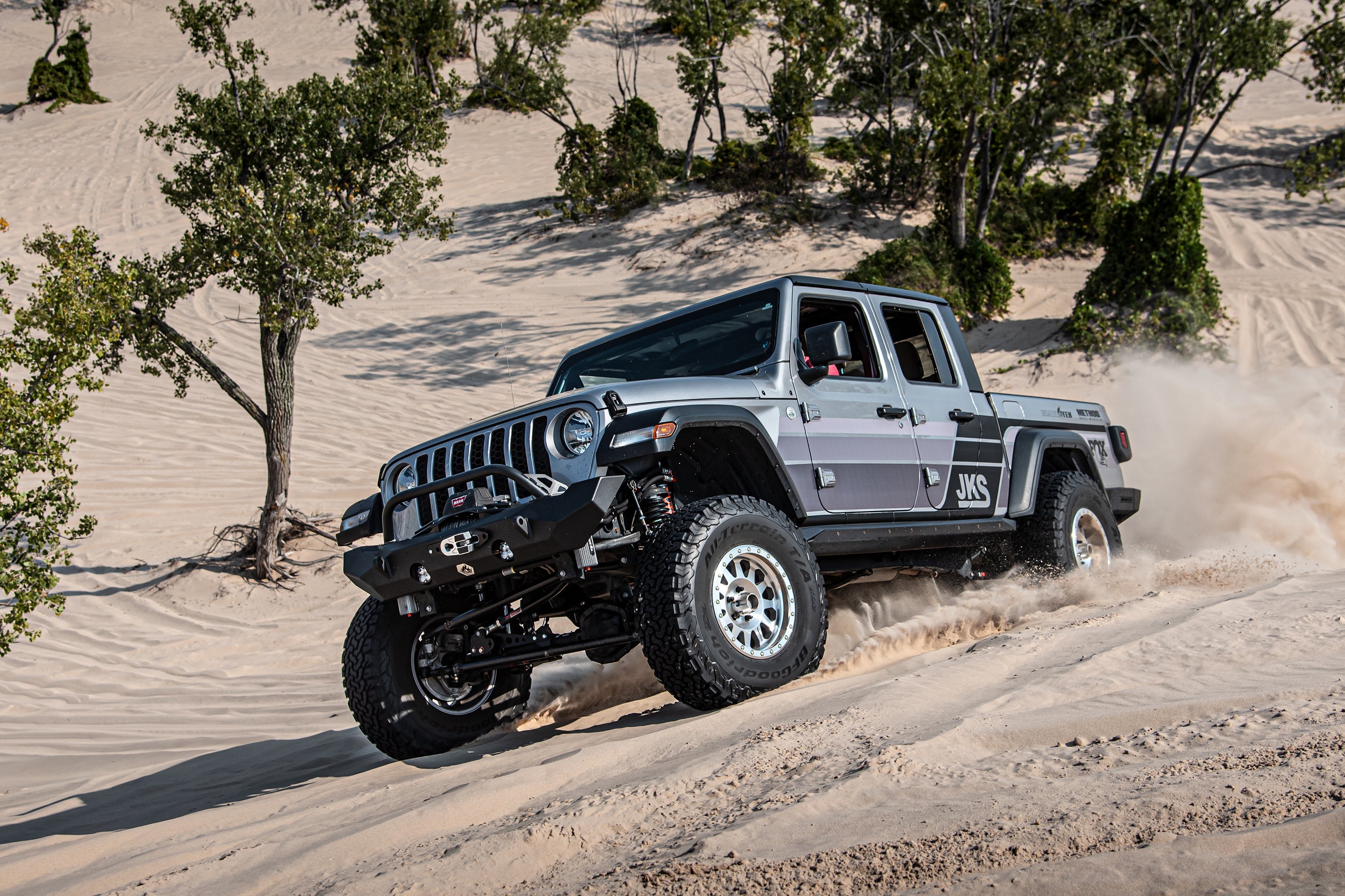 3.5-inch lift kit for Gladiator JT installed on a Jeep driving through sandy terrain, showcasing offroad capability.