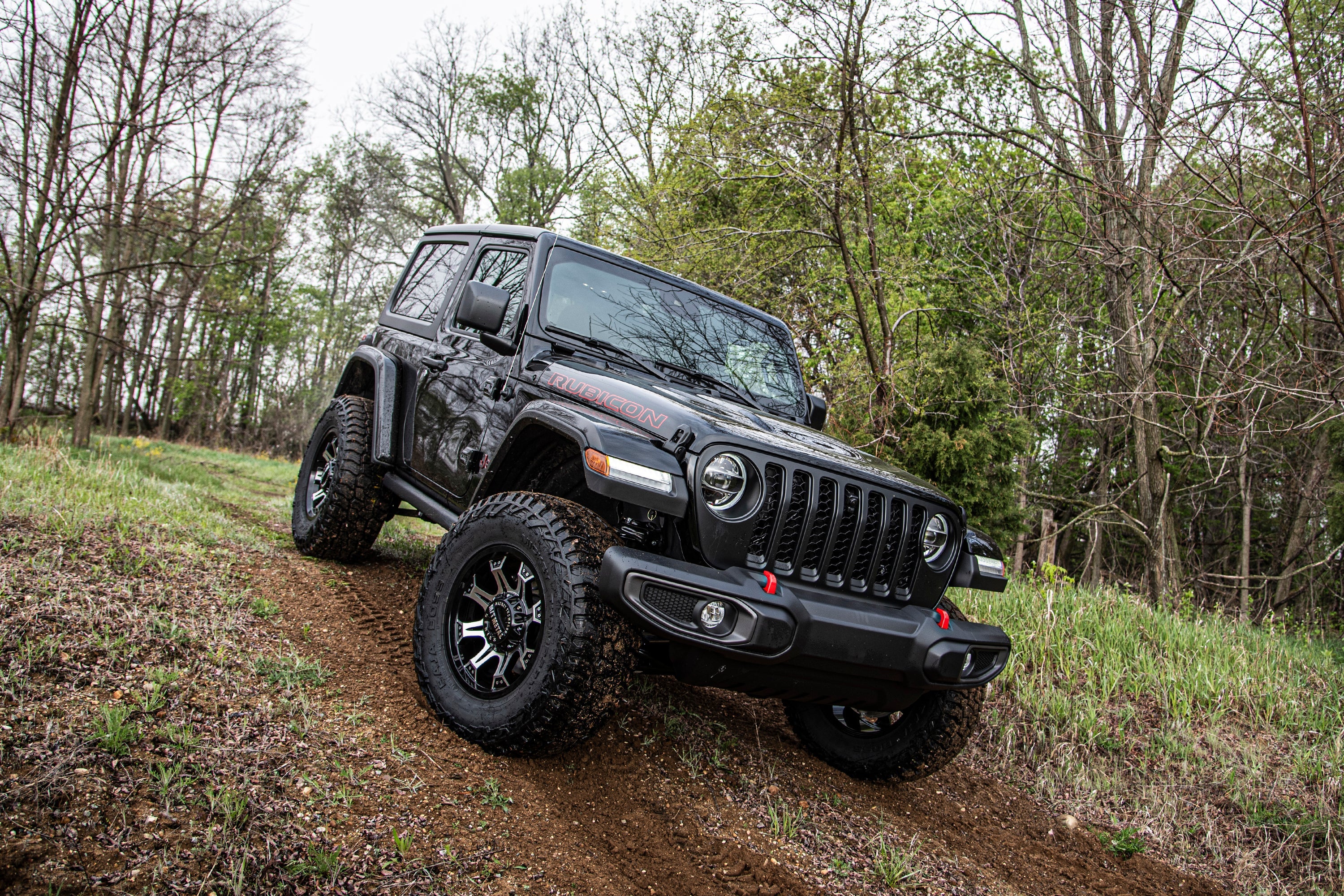 3 inch lift kit for Jeep Wrangler JL 2-Door (2018-2025) showcased on an offroad trail with rugged terrain.
