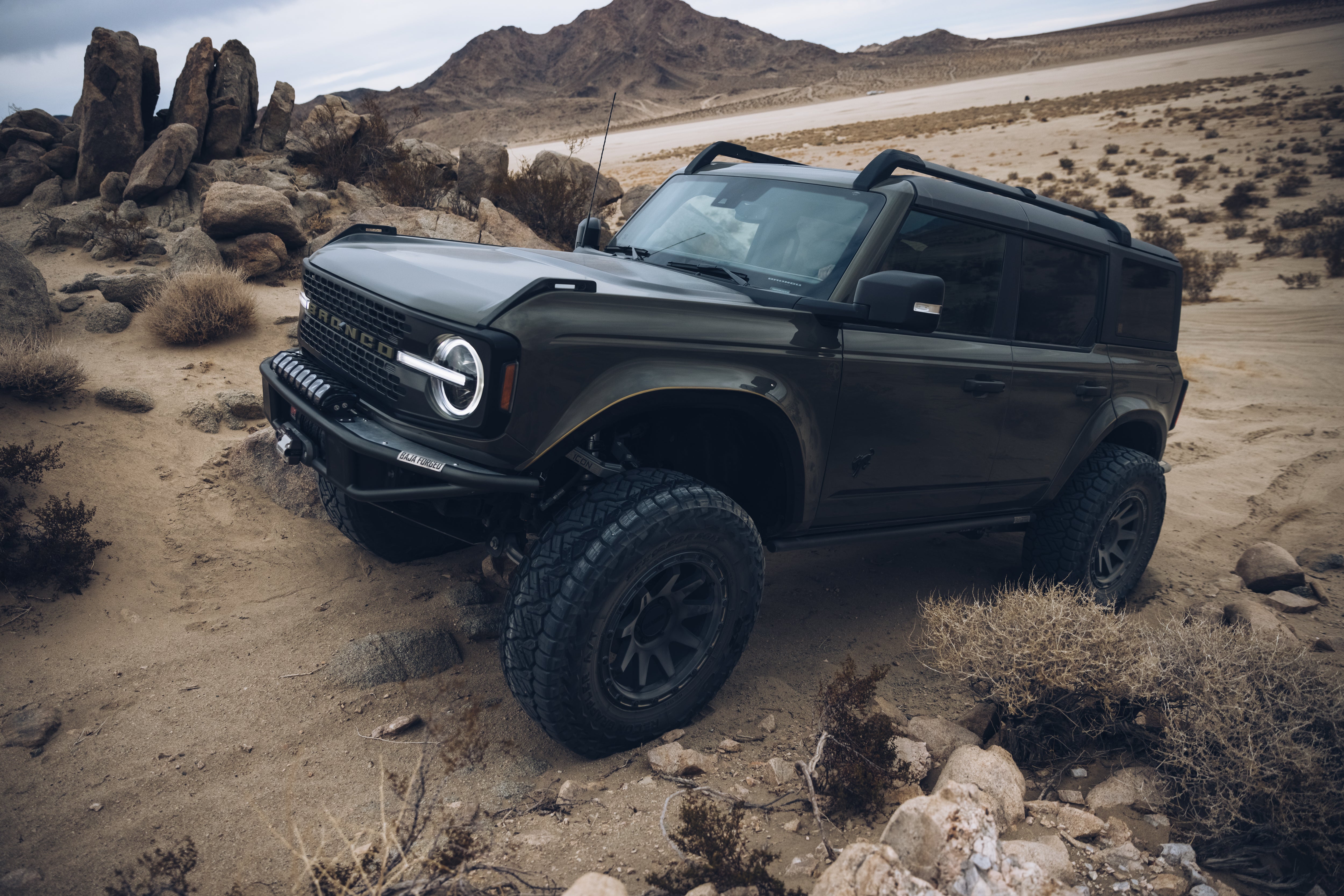 2021 Outer Banks BAJA FORGED off-road vehicle navigating rocky terrain in a desert landscape, showcasing rugged design and capability.