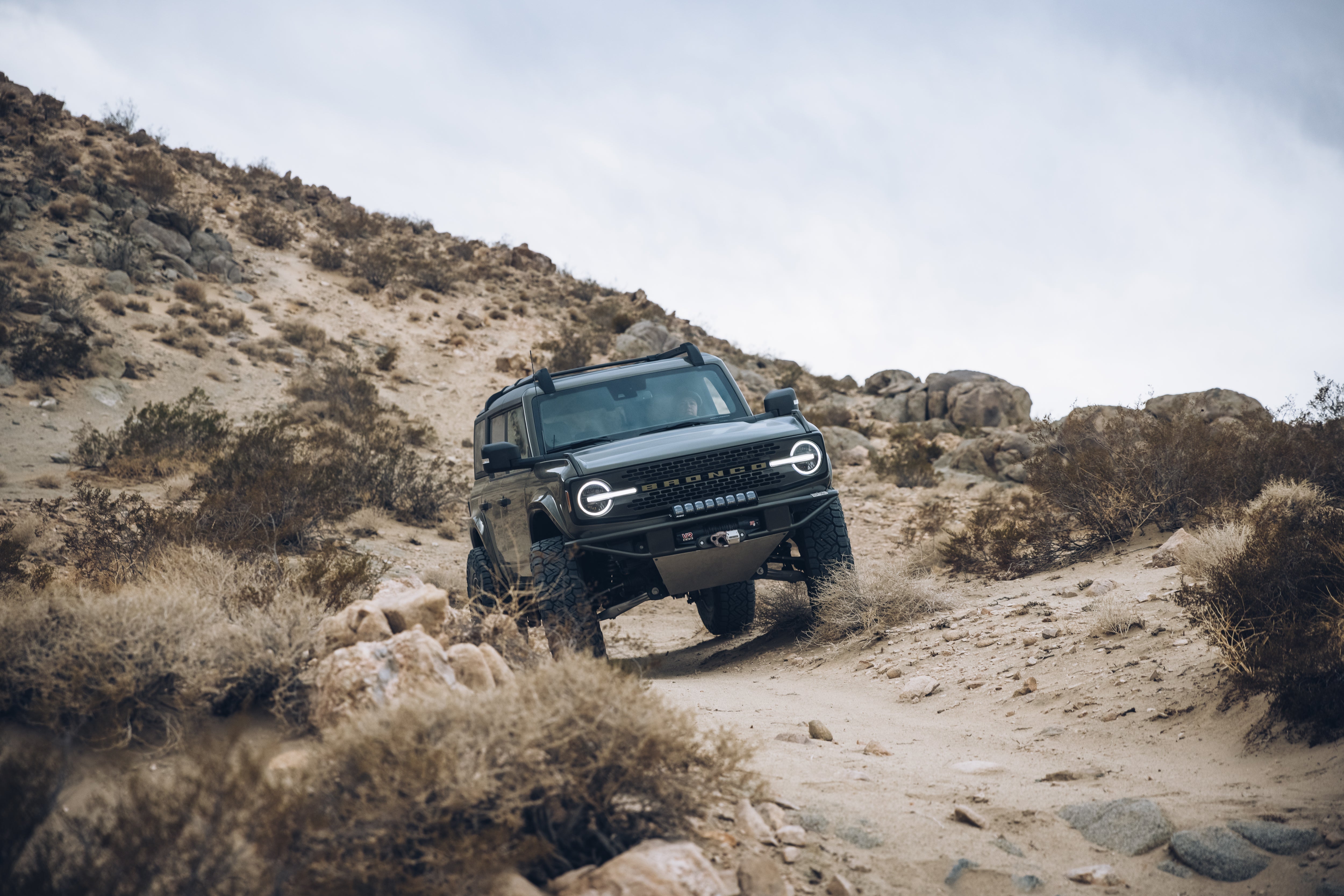 2021 Outer Banks Bronco by BAJA FORGED navigating a rocky desert trail, showcasing off-road capabilities and rugged design.