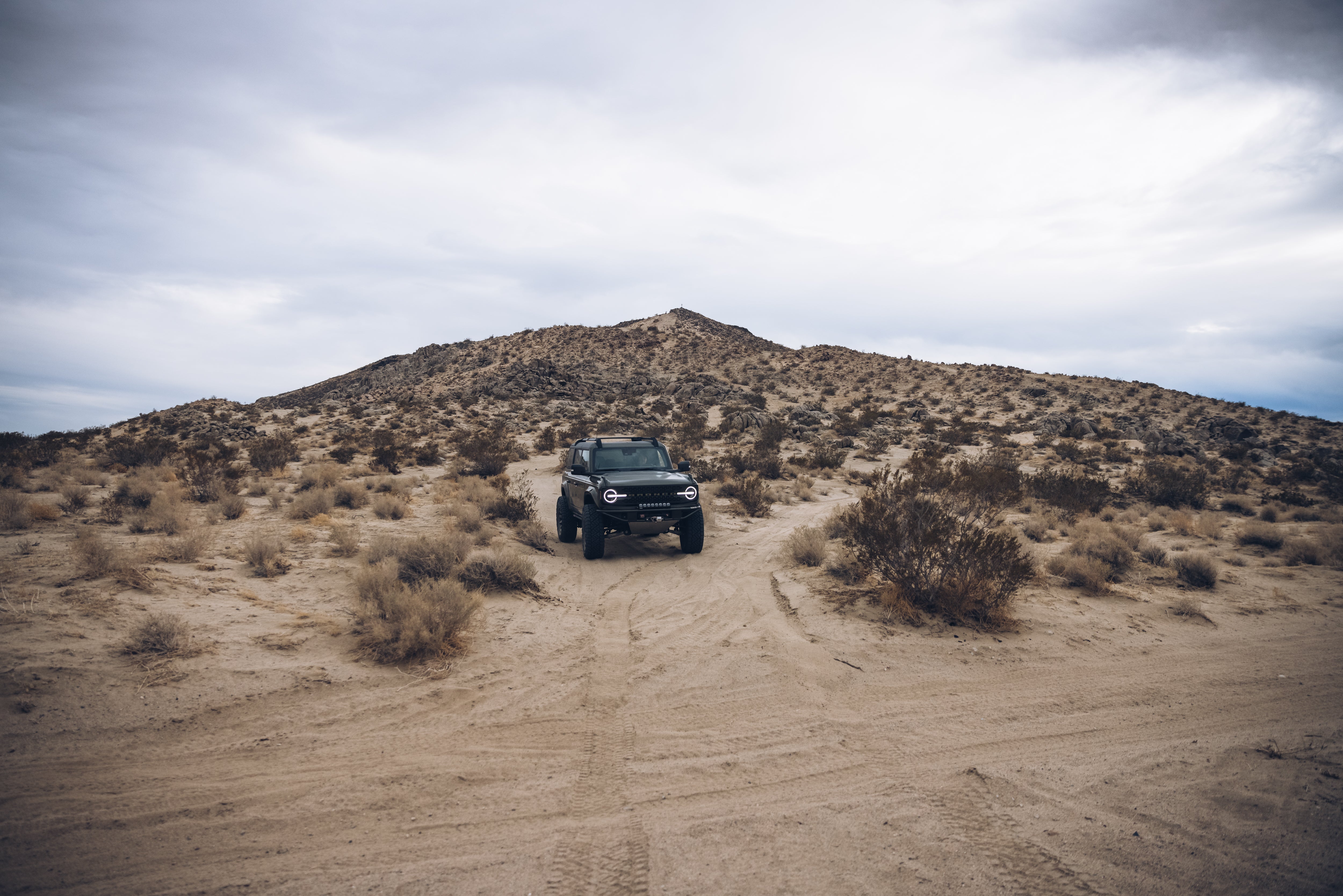 2021 Outer Banks BAJA FORGED vehicle parked on sandy terrain with a desert landscape in the background.