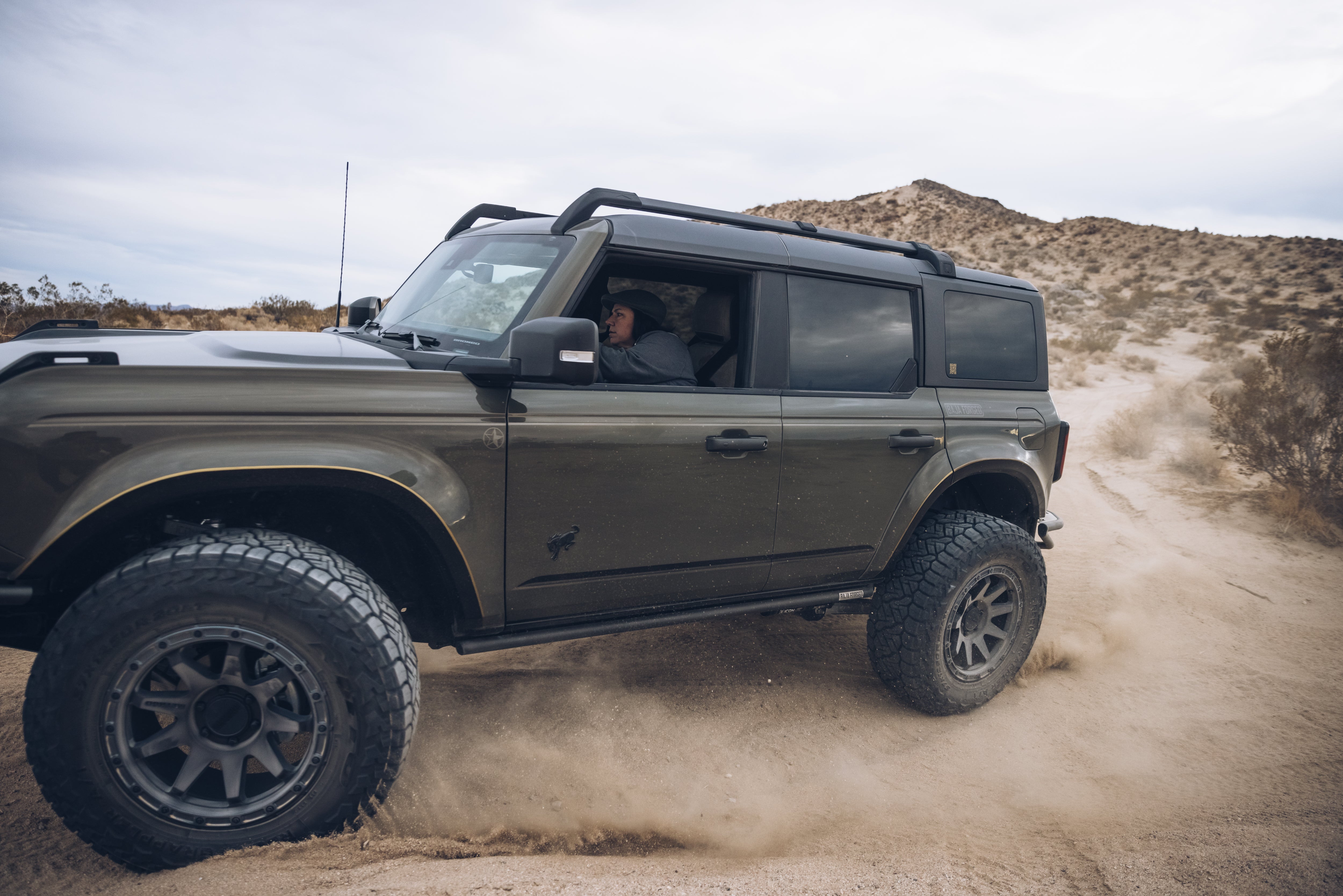 2021 Outer Banks BAJA FORGED off-road vehicle navigating sandy terrain with a driver inside.