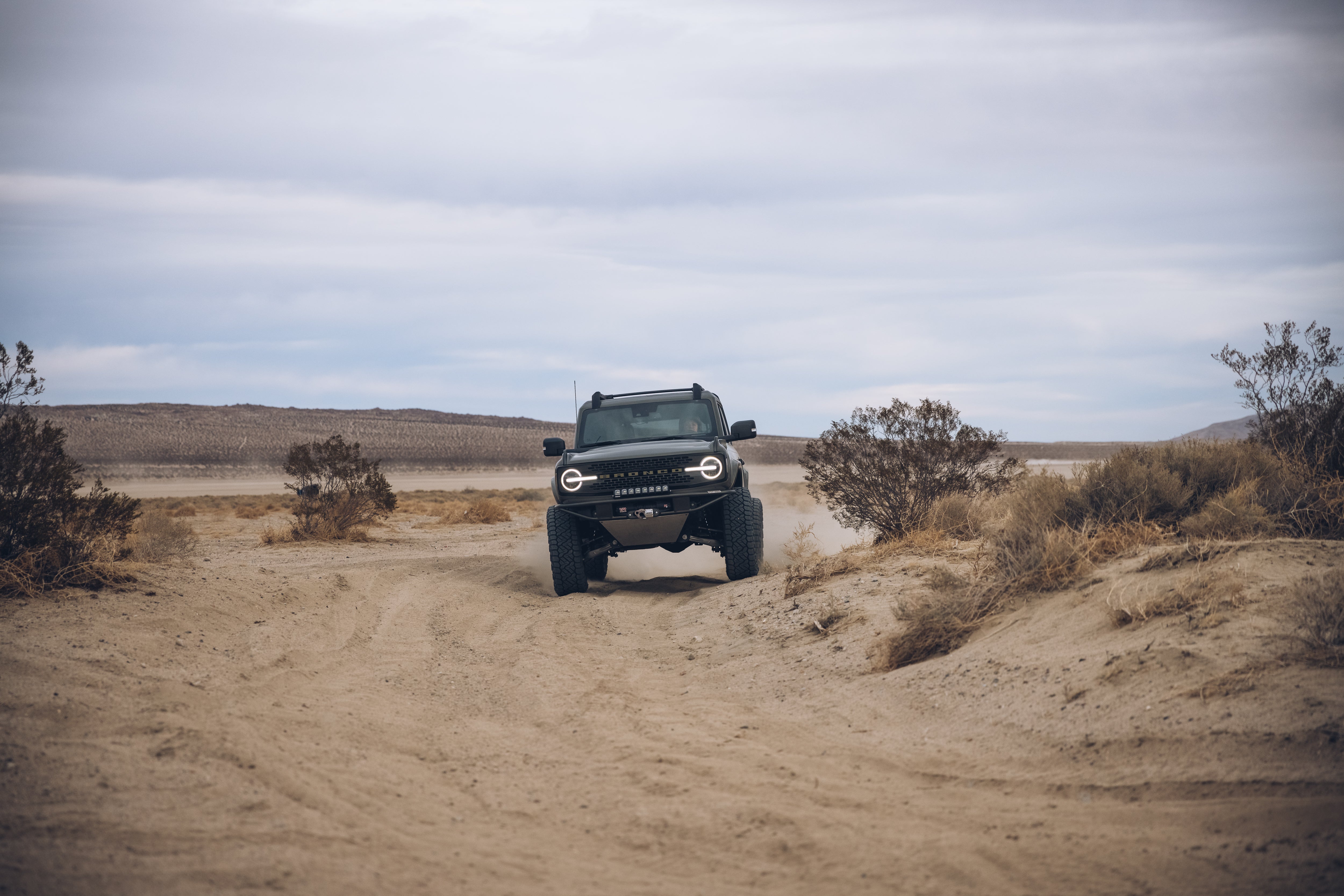 2021 Outer Banks BAJA FORGED off-road vehicle navigating a sandy trail in a desert landscape.