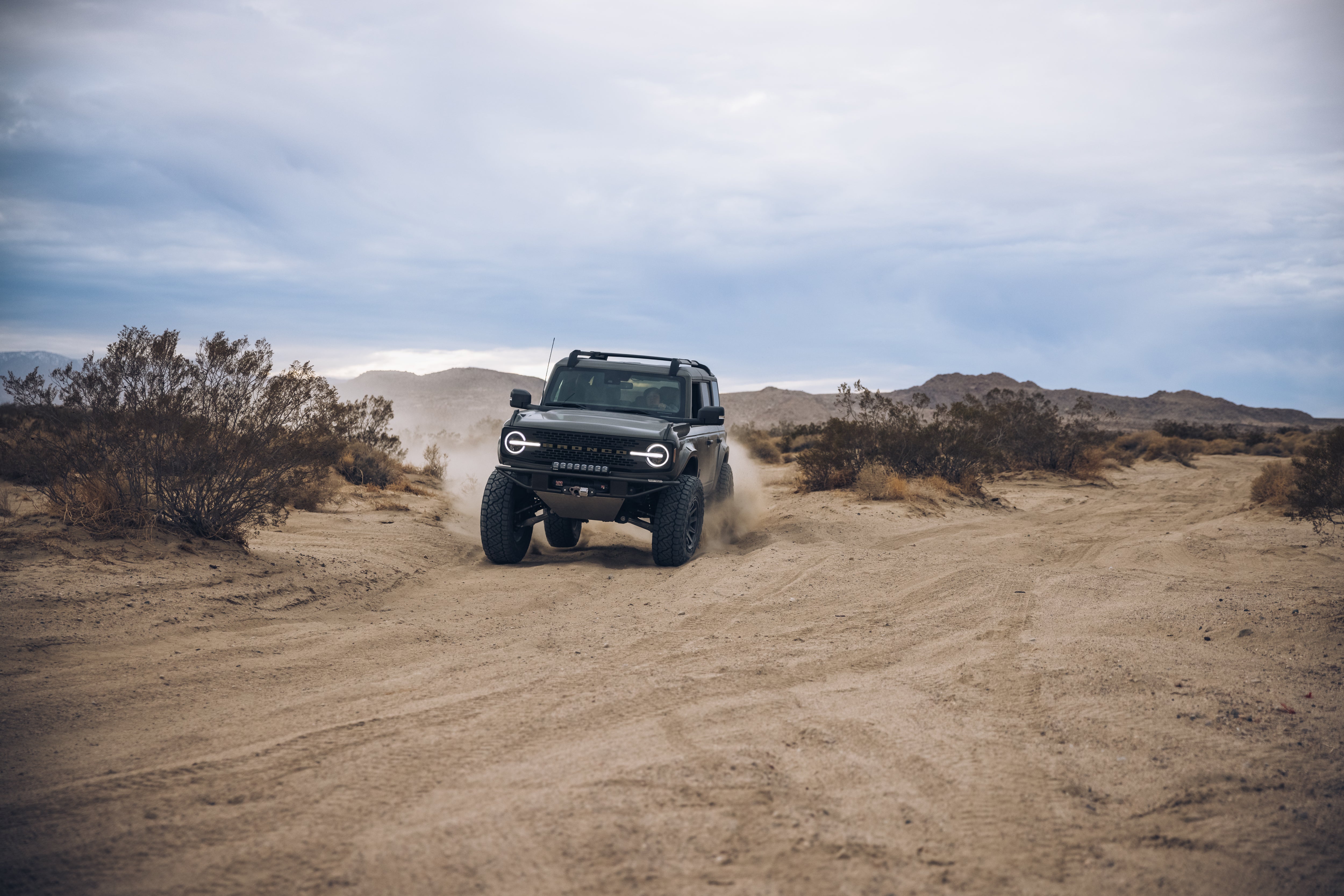2021 Outer Banks BAJA FORGED off-road vehicle navigating a sandy desert trail, showcasing rugged terrain capability.