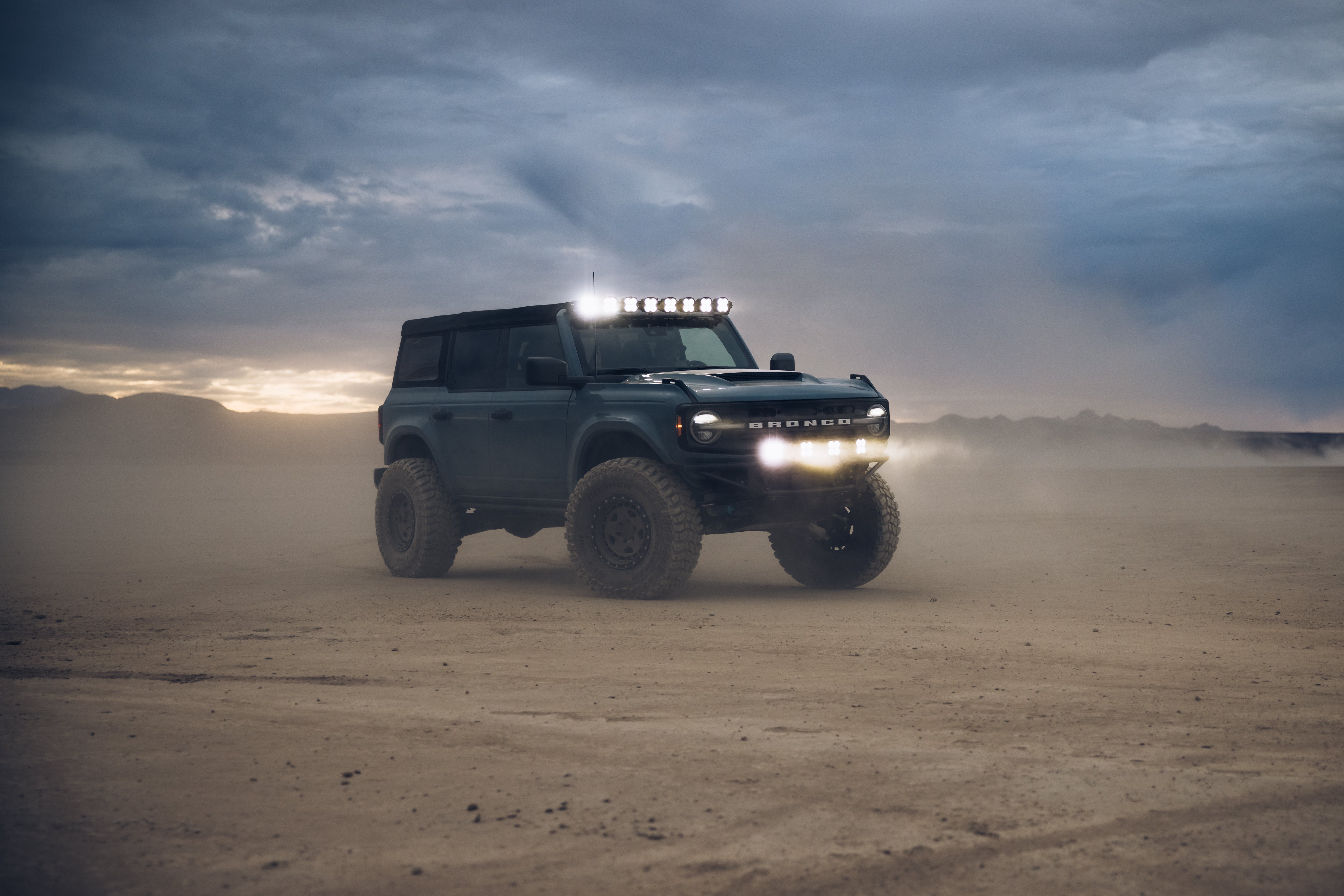 ADV Fiberglass 2021 Ford Bronco equipped for off-road adventures with rugged tires and LED light bar in a desert setting.