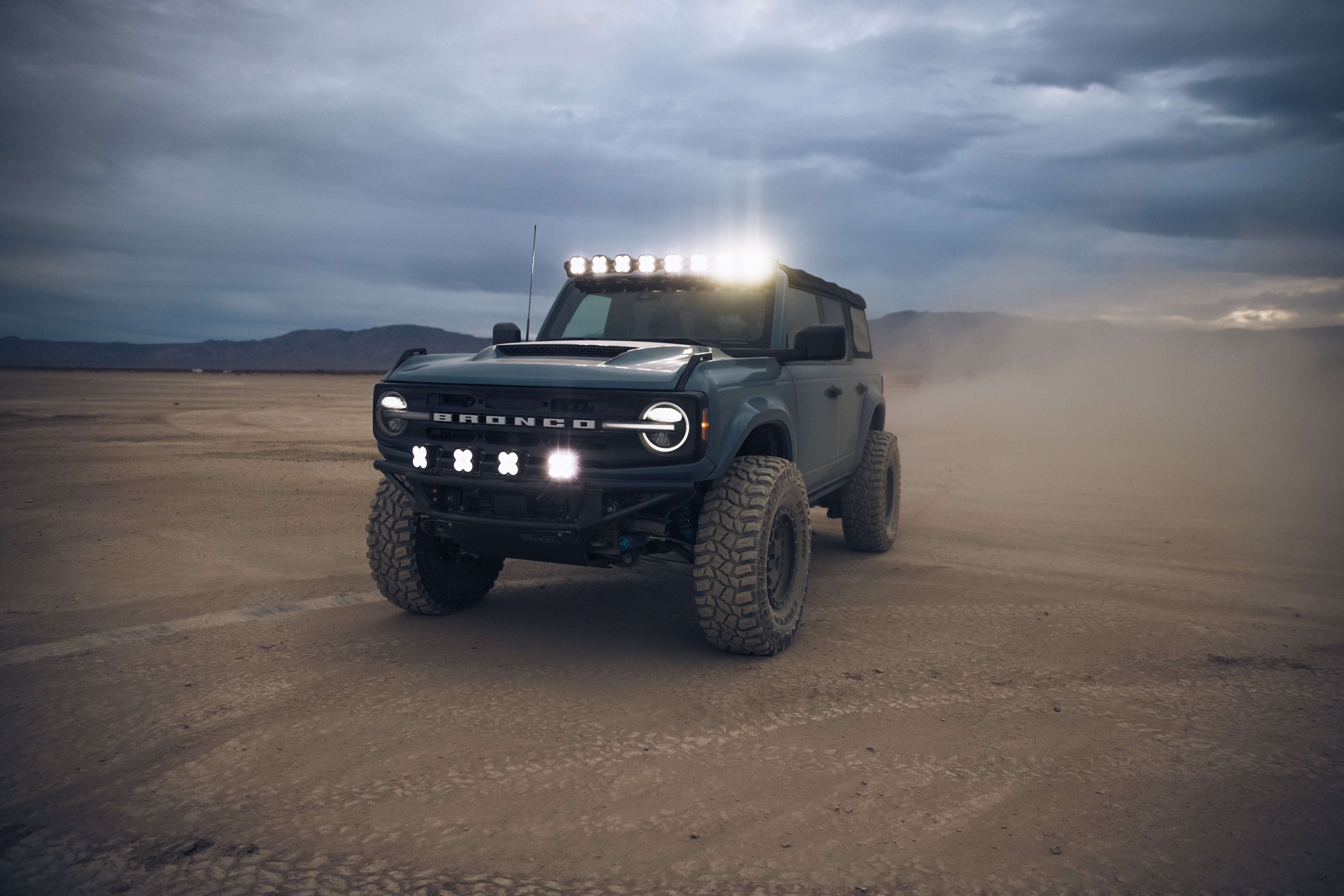 ADV Fiberglass 2021 Ford Bronco with off-road lights, showcasing rugged design in a desert landscape.