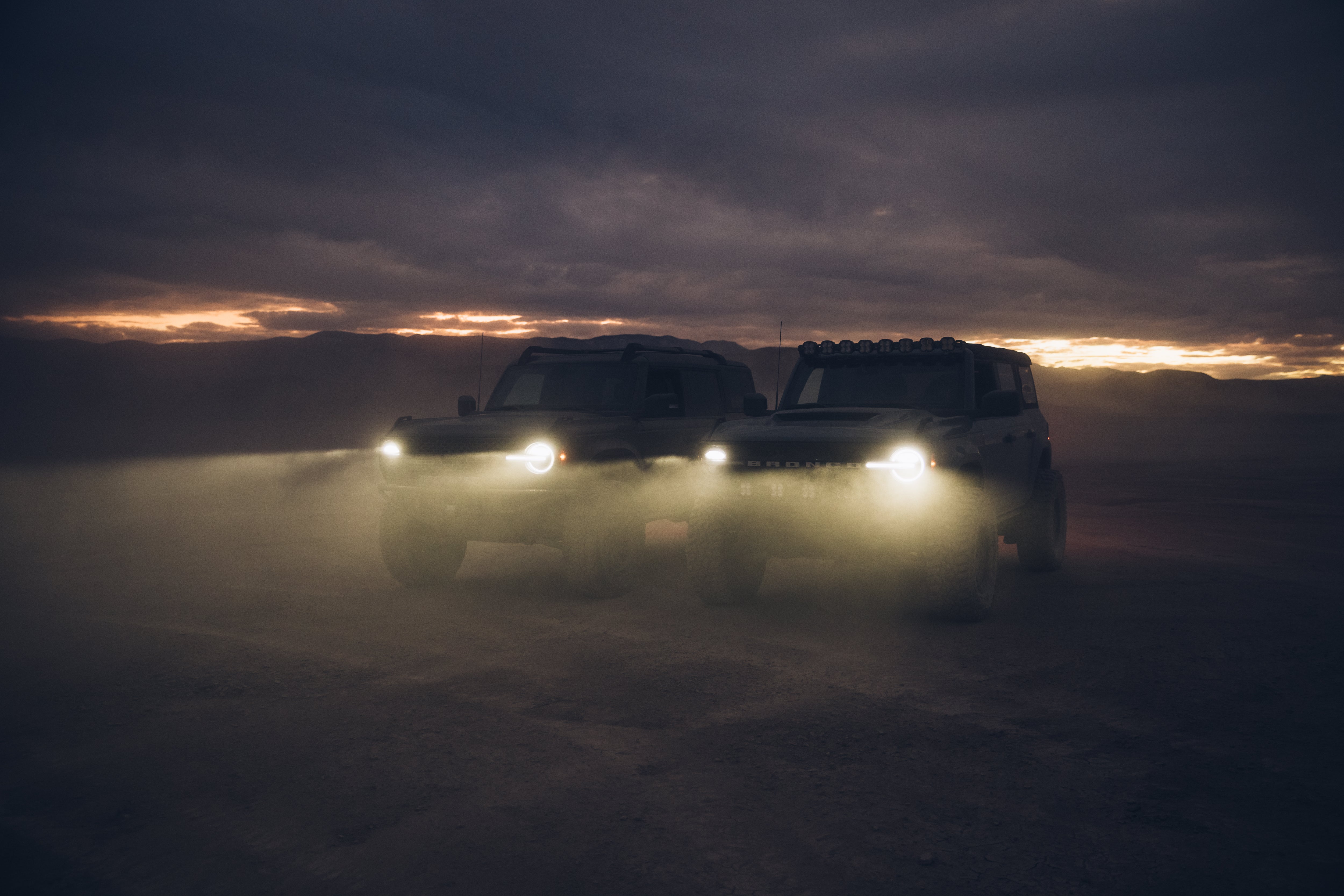 ADV Fiberglass 2021 Ford trucks in a desert setting, showcasing off-road capabilities with foggy conditions and dramatic lighting.
