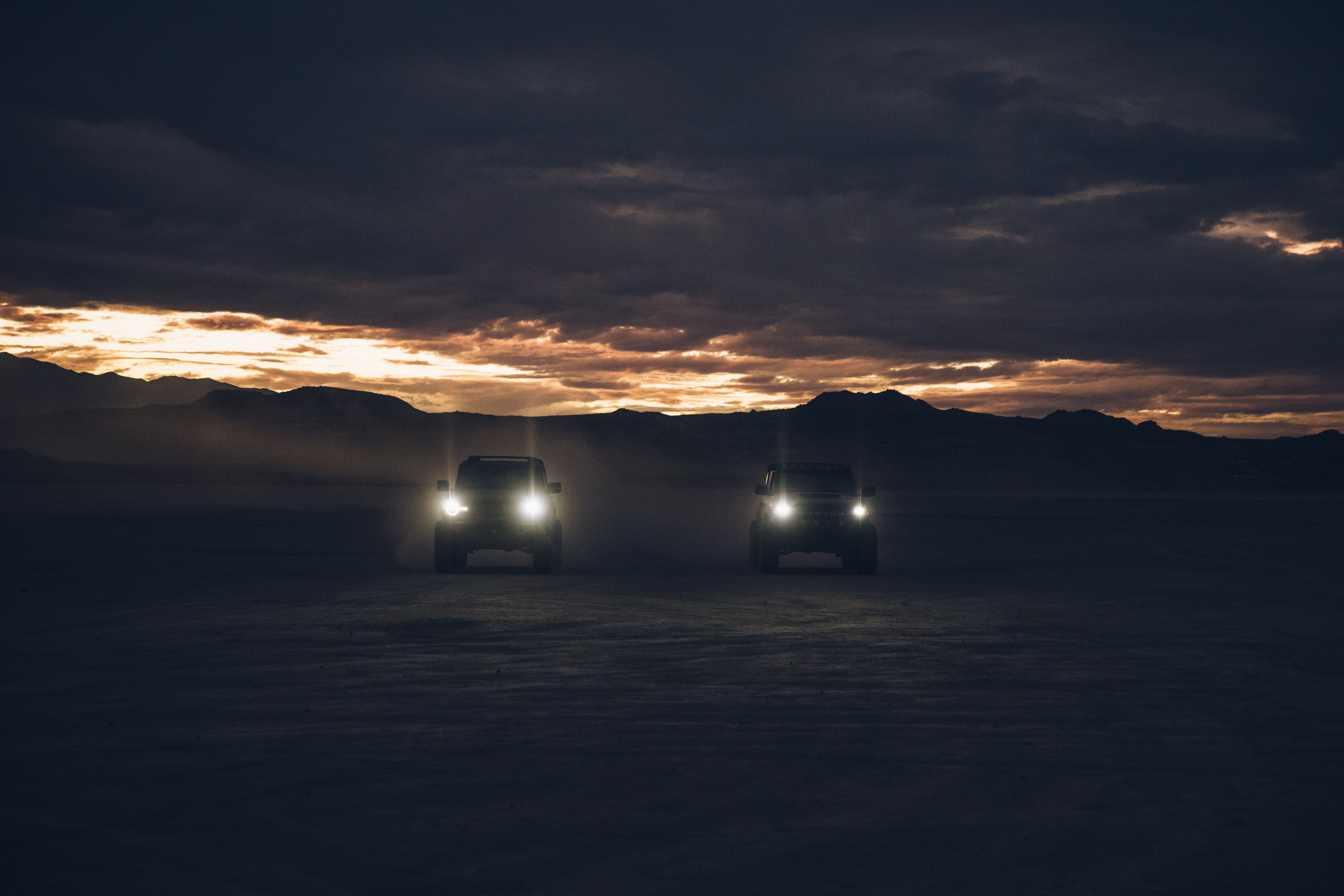 ADV Fiberglass 2021 Ford trucks driving in a desert landscape at dusk, showcasing offroad capabilities and rugged design.