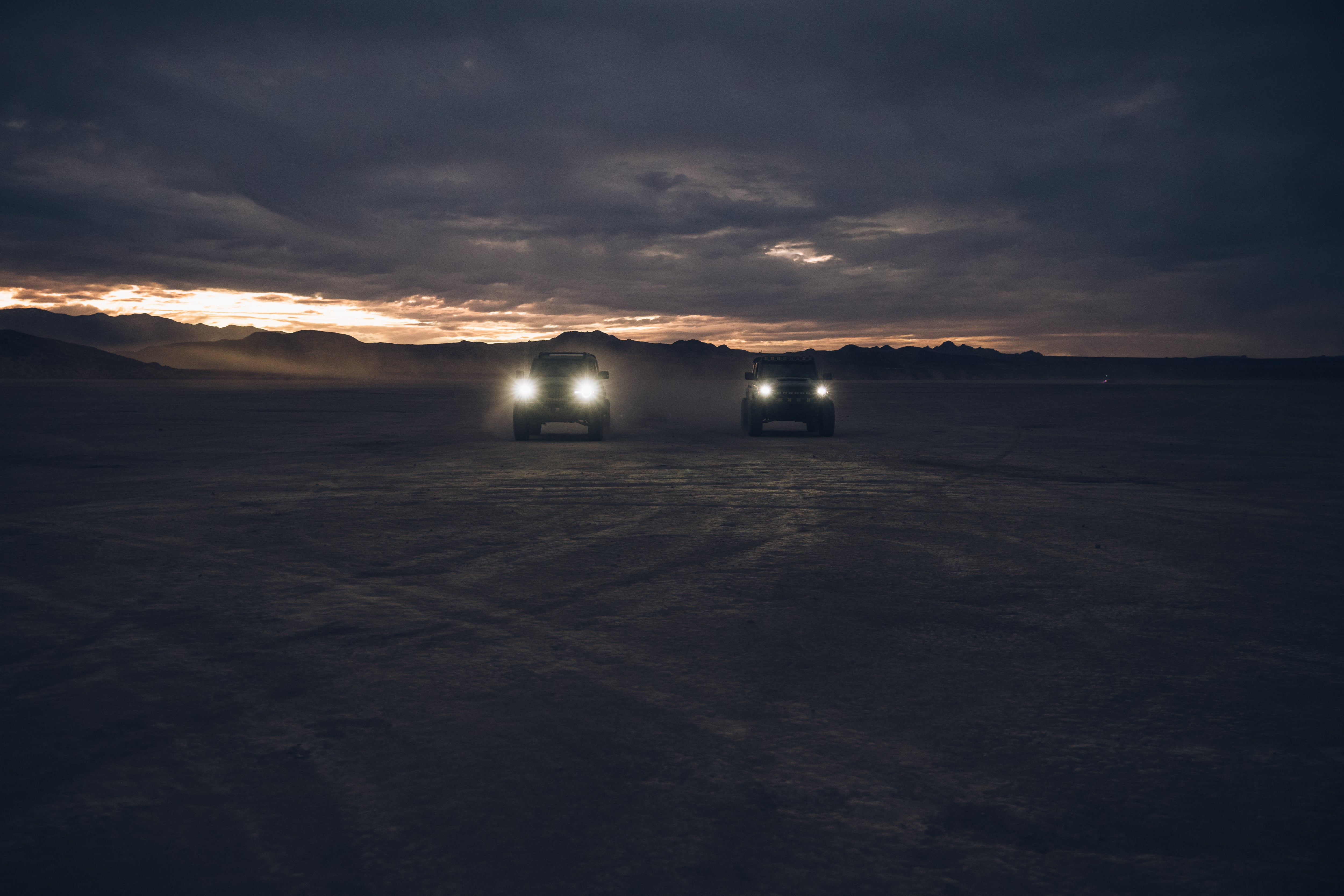 ADV Fiberglass 2021 Ford trucks illuminated at dusk, showcasing offroad capabilities in a rugged landscape.