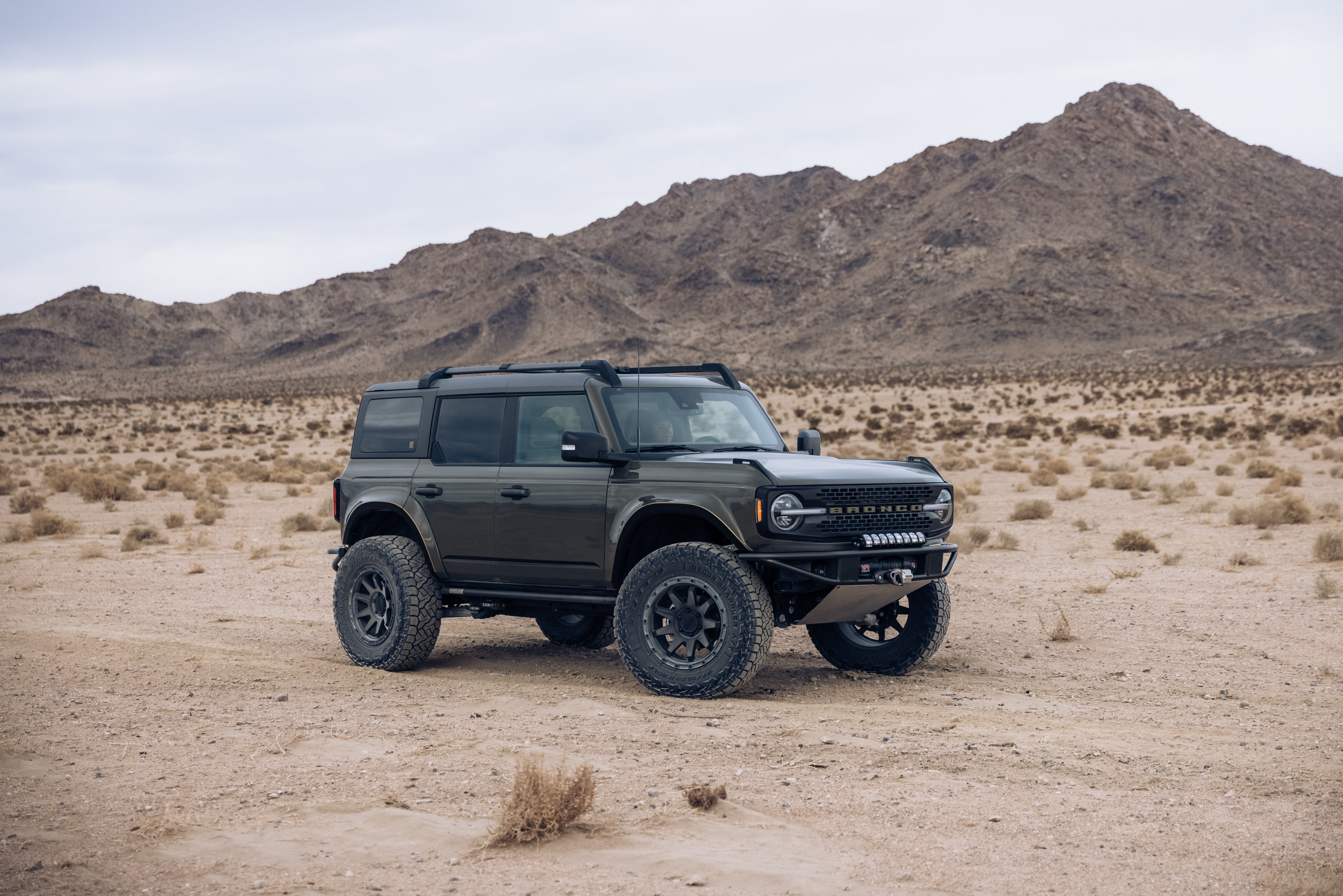 2021 Outer Banks Bronco with BAJA FORGED accessories parked in a desert landscape, showcasing rugged off-road capabilities.