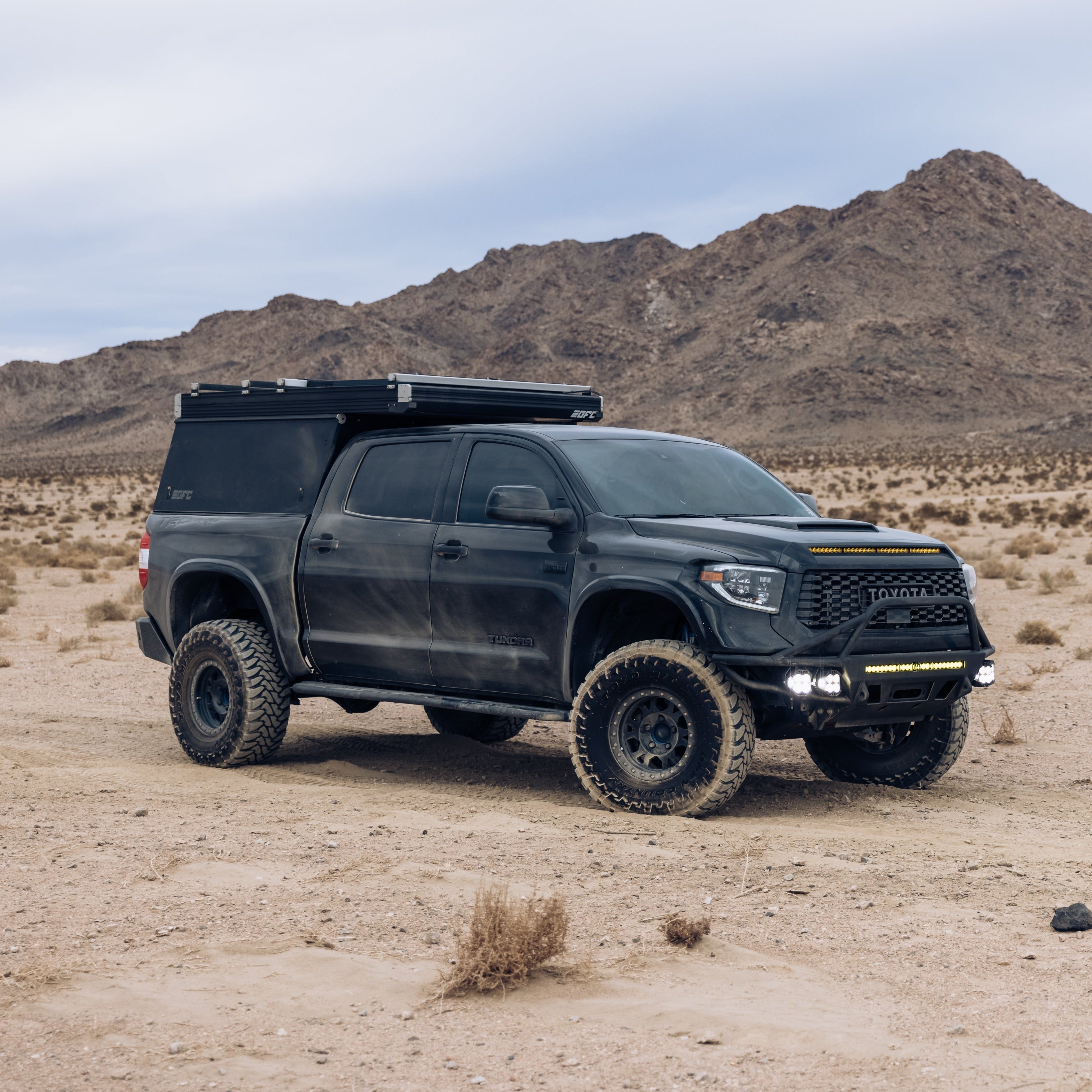 2014-2021 Toyota Tundra fenders showcased on a rugged black truck in a desert landscape, highlighting offroad capabilities.