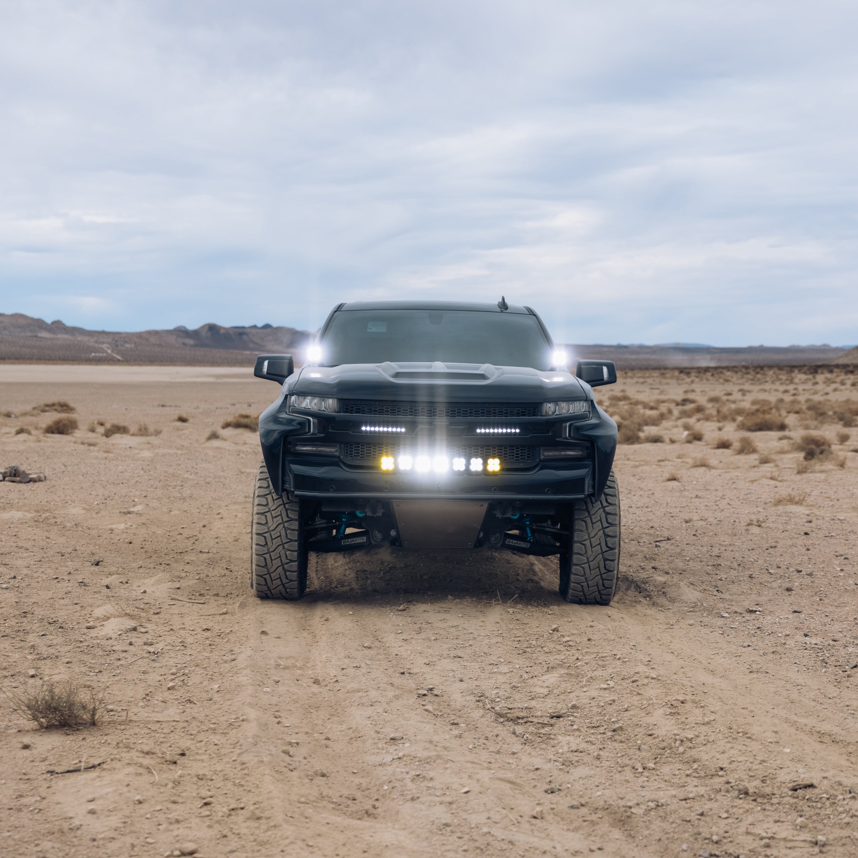 2019-2025 Chevrolet Silverado with custom bedsides parked on a desert landscape, showcasing rugged off-road capabilities.