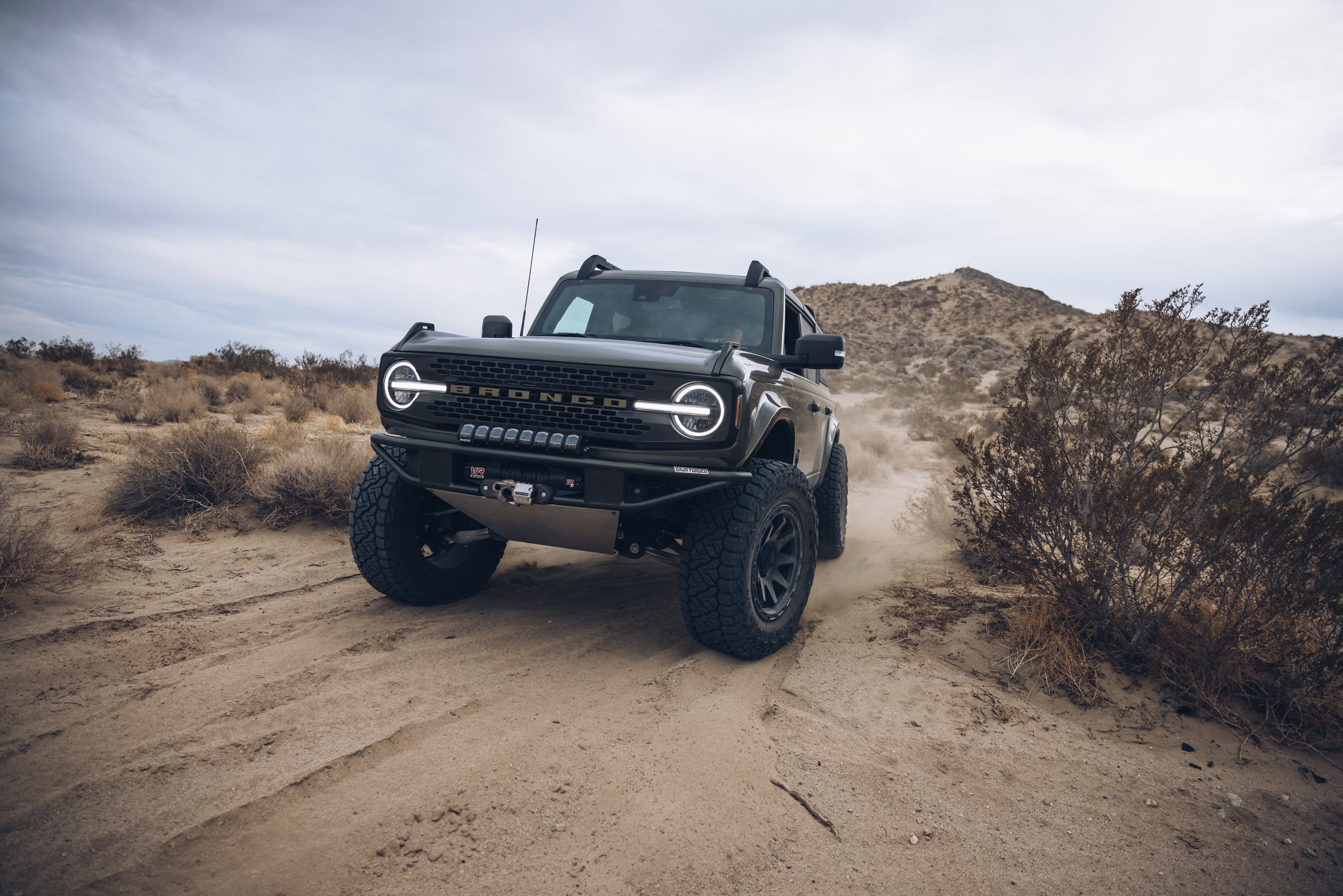 2021 Outer Banks Bronco with BAJA FORGED accessories driving through sandy terrain, showcasing off-road capabilities.