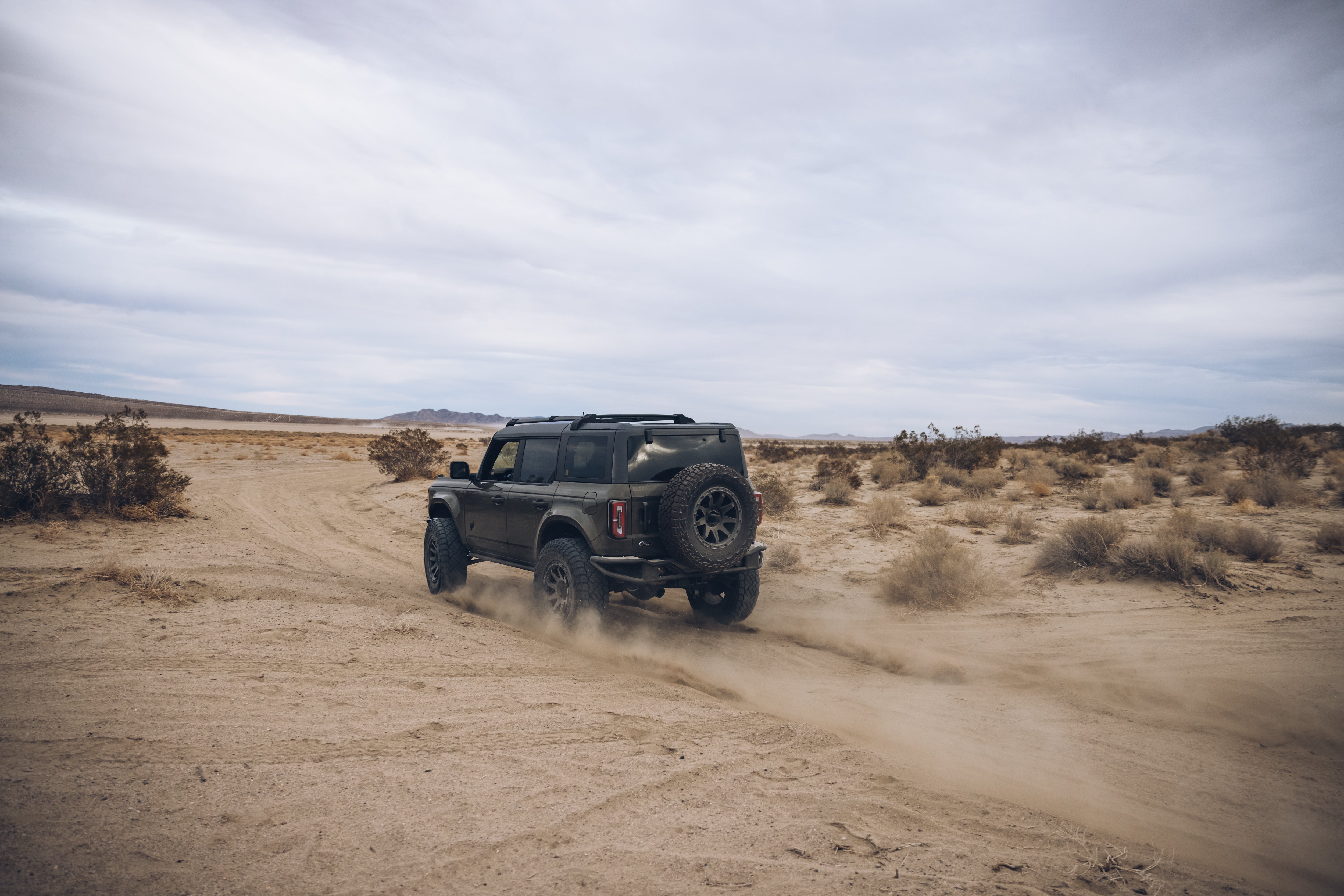 2021 Outer Banks BAJA FORGED SUV driving through sandy desert terrain, showcasing off-road capabilities and rugged design.