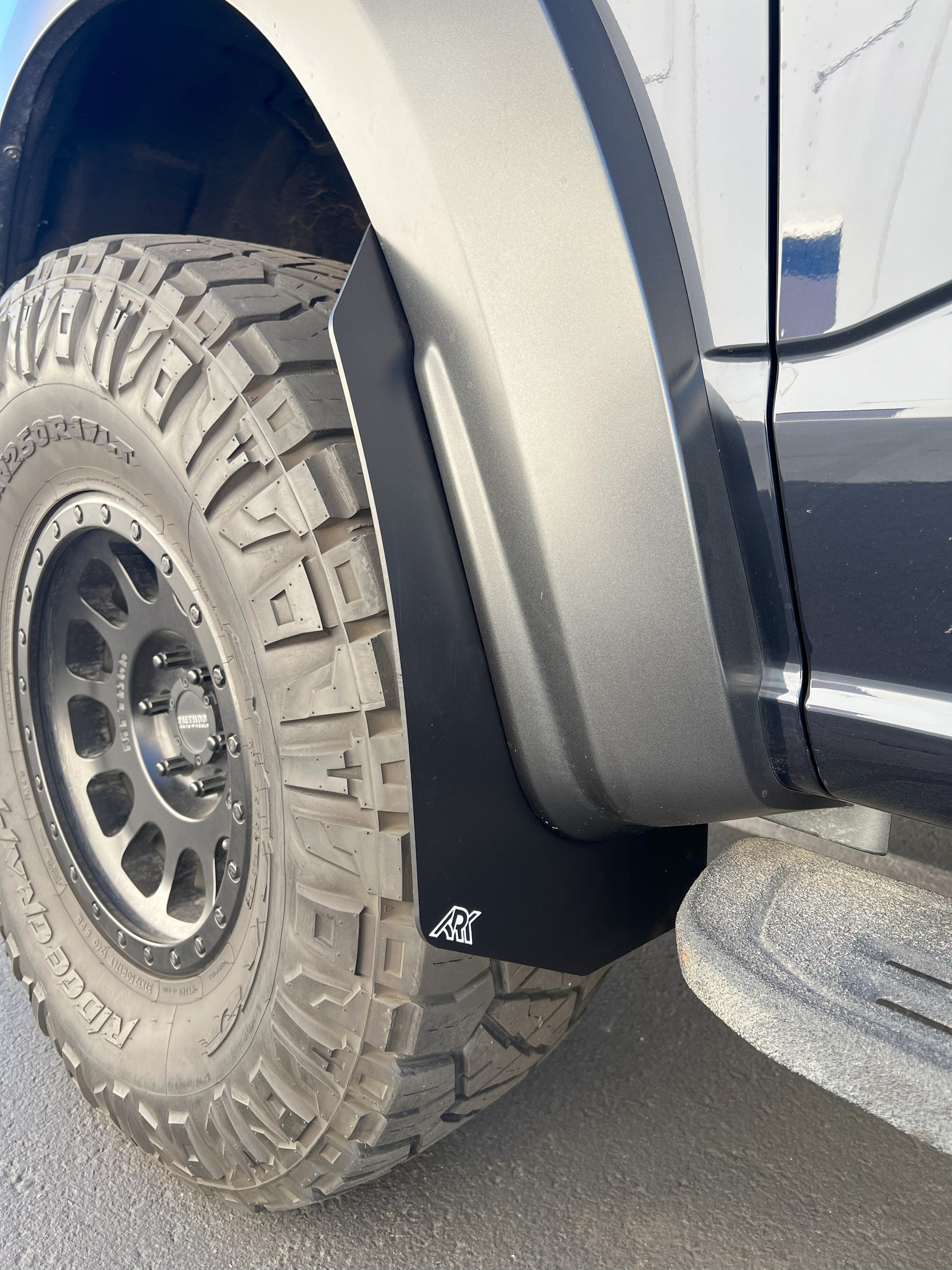 2021+ Ford Raptor mid mud flaps installed on a truck, showcasing rugged design and tire protection.