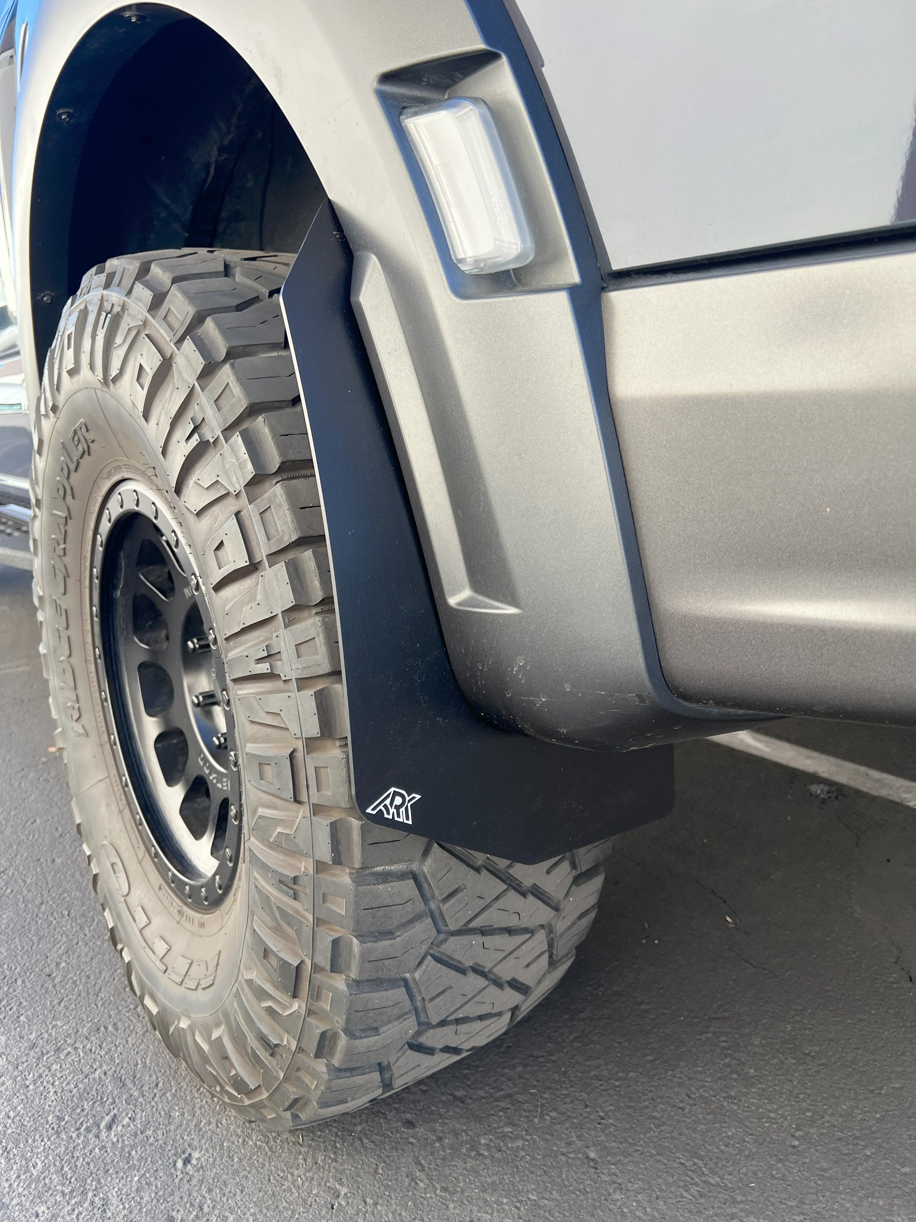 2021+ Ford Raptor mid mud flaps mounted on a rugged tire, designed for enhanced off-road protection and style.