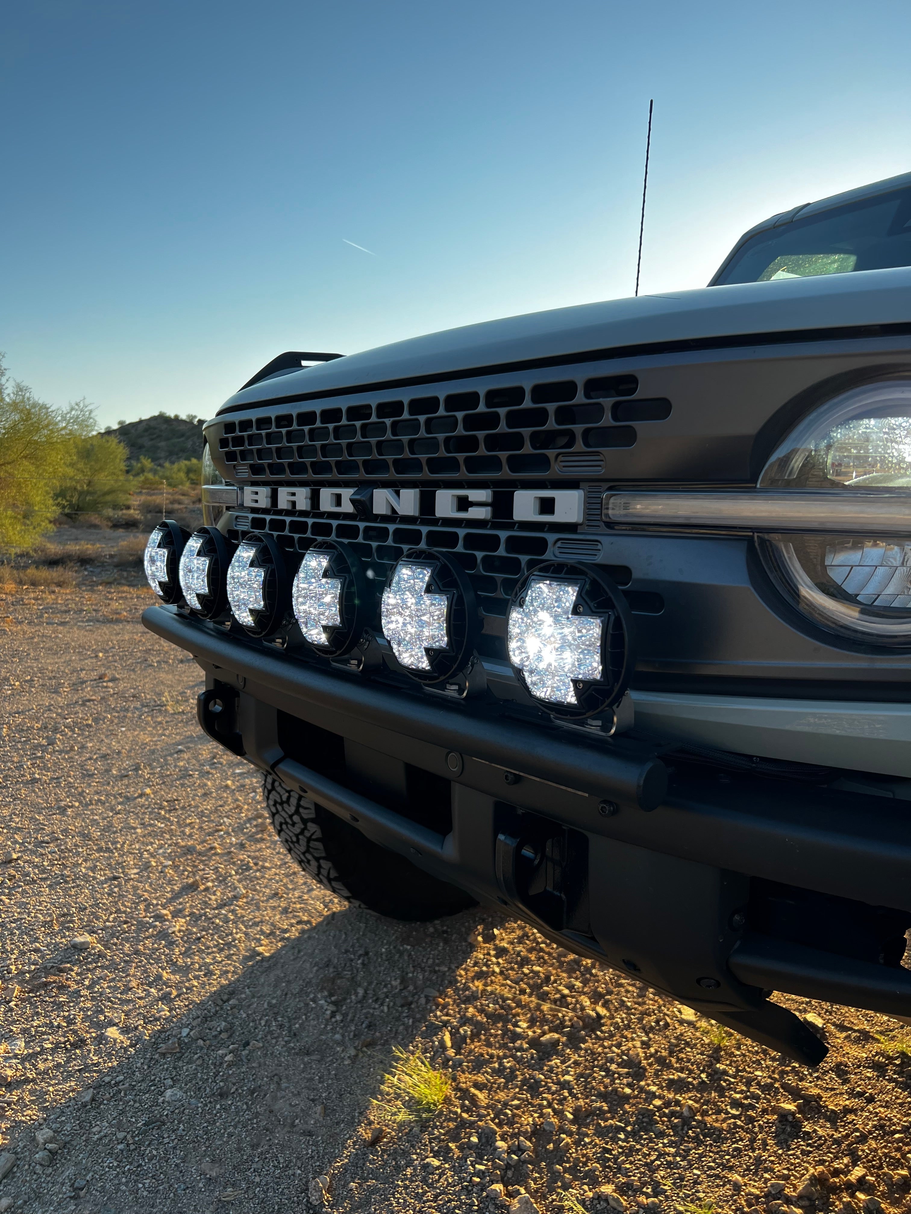 6th Gen Bronco front light mount kit installed on a modular stock bumper, showcasing multiple mounted lights for offroad use.