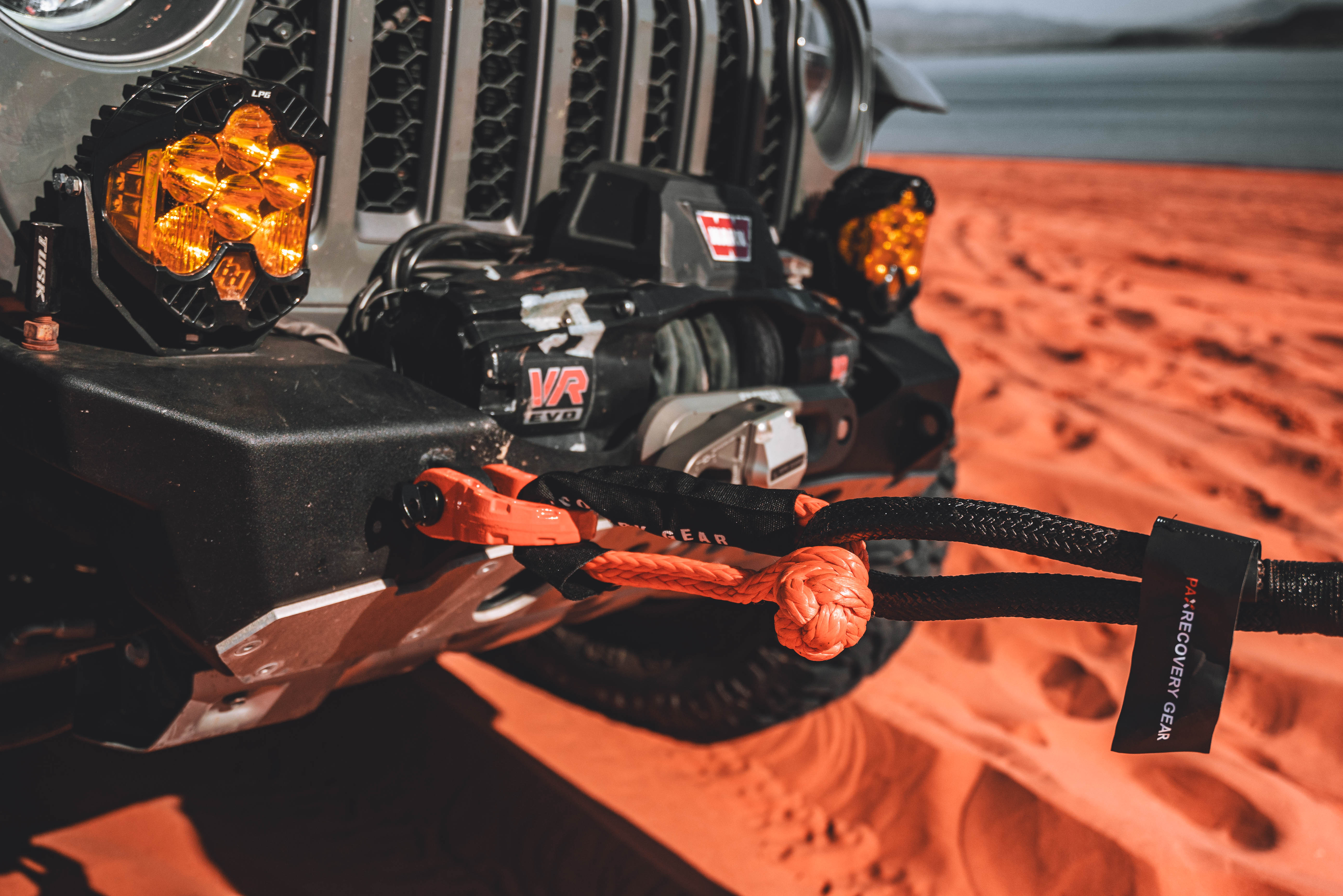 1/2 inch soft shackle secured to a Jeep's front bumper, showcasing its durability and offroad capability in a sandy environment.