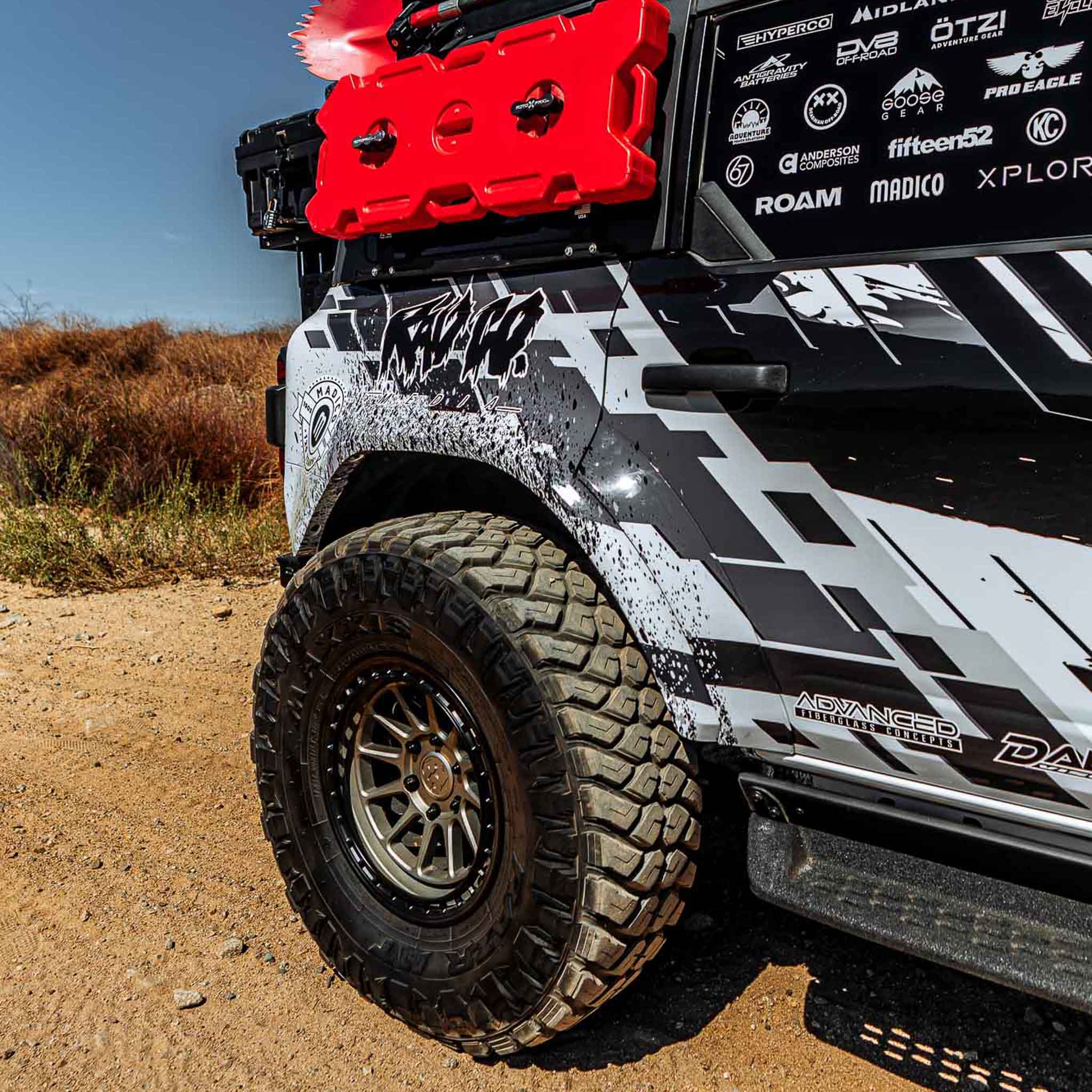 2022-2025 Ford Bronco Raptor rear quarter kit showcasing rugged design and off-road tire on a dirt trail.