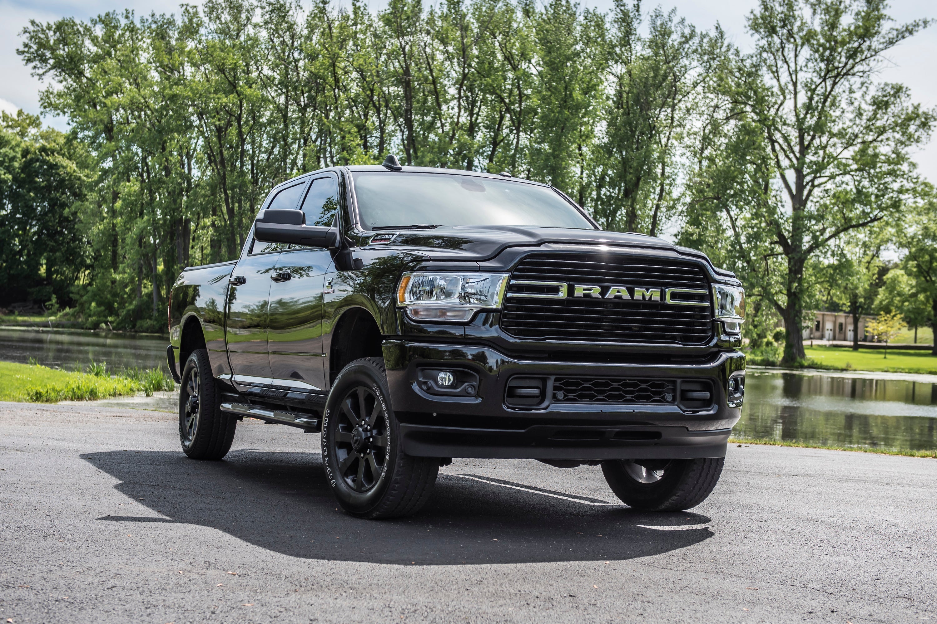 Black Ram 2500 4WD truck with a 2-inch leveling kit parked by a serene landscape, showcasing enhanced stance and style.