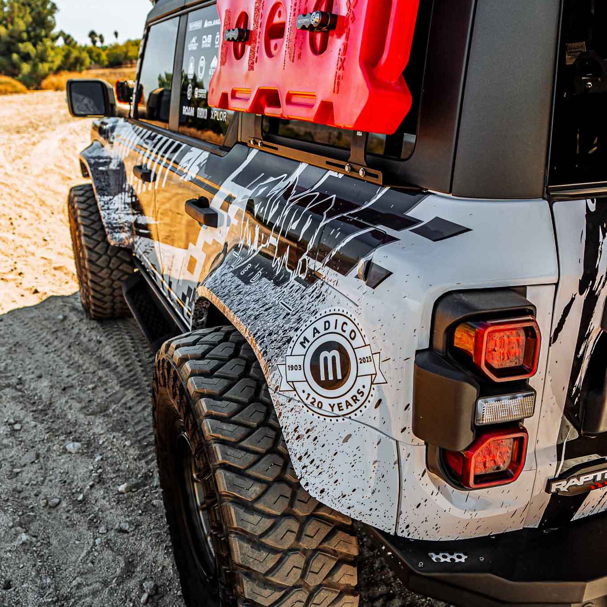 2022-2025 Ford Bronco Raptor showcasing a rear quarter kit with rugged design and off-road tires in a sandy terrain.