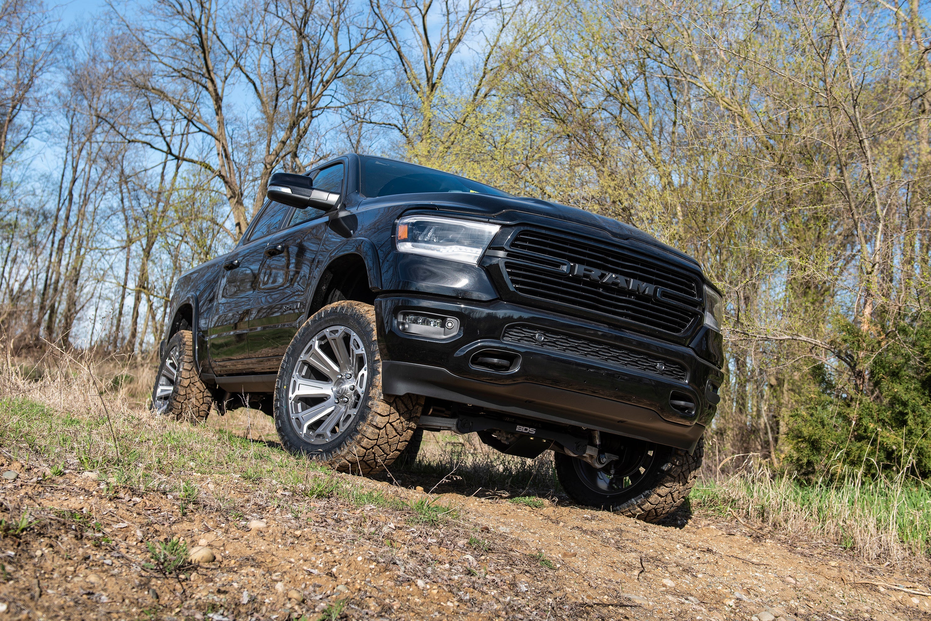 4-inch lift kit with FOX 2.5 Performance Elite coil-over installed on a black Ram 1500 4WD, showcasing off-road capability.