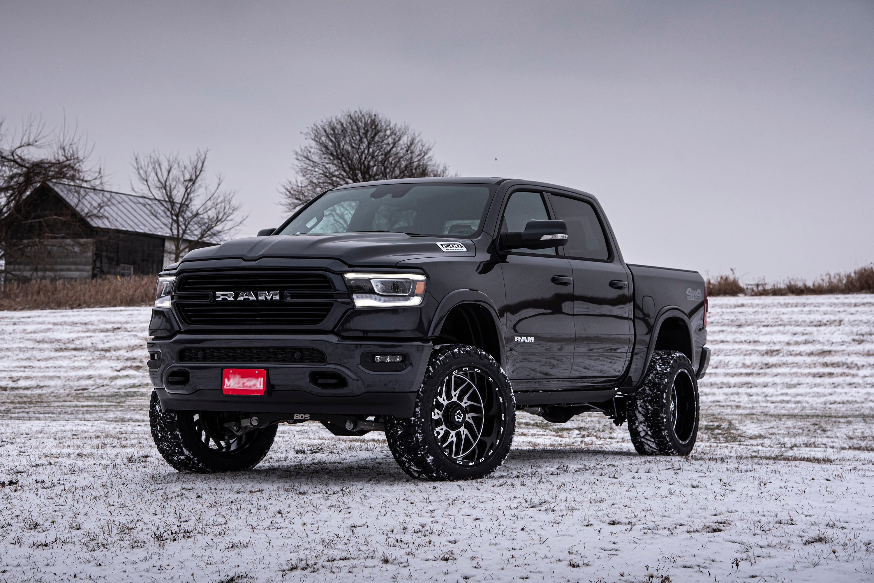 5-inch lift kit installed on a black Ram 1500 Rebel in a snowy landscape, showcasing enhanced off-road capabilities.