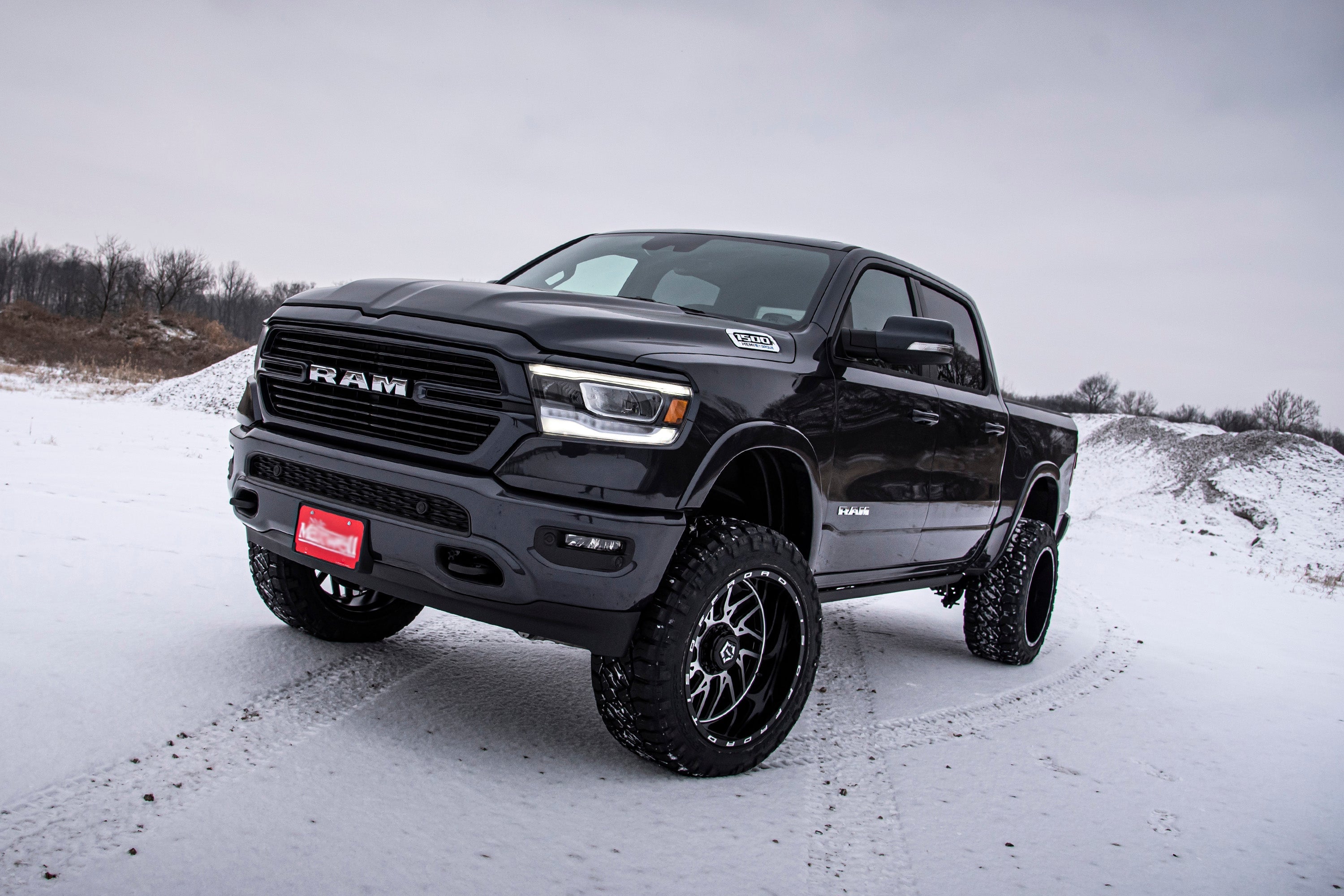6-inch lift kit with FOX 2.5 coil-over installed on a black Ram 1500 4WD, showcasing enhanced off-road capability in snowy terrain.