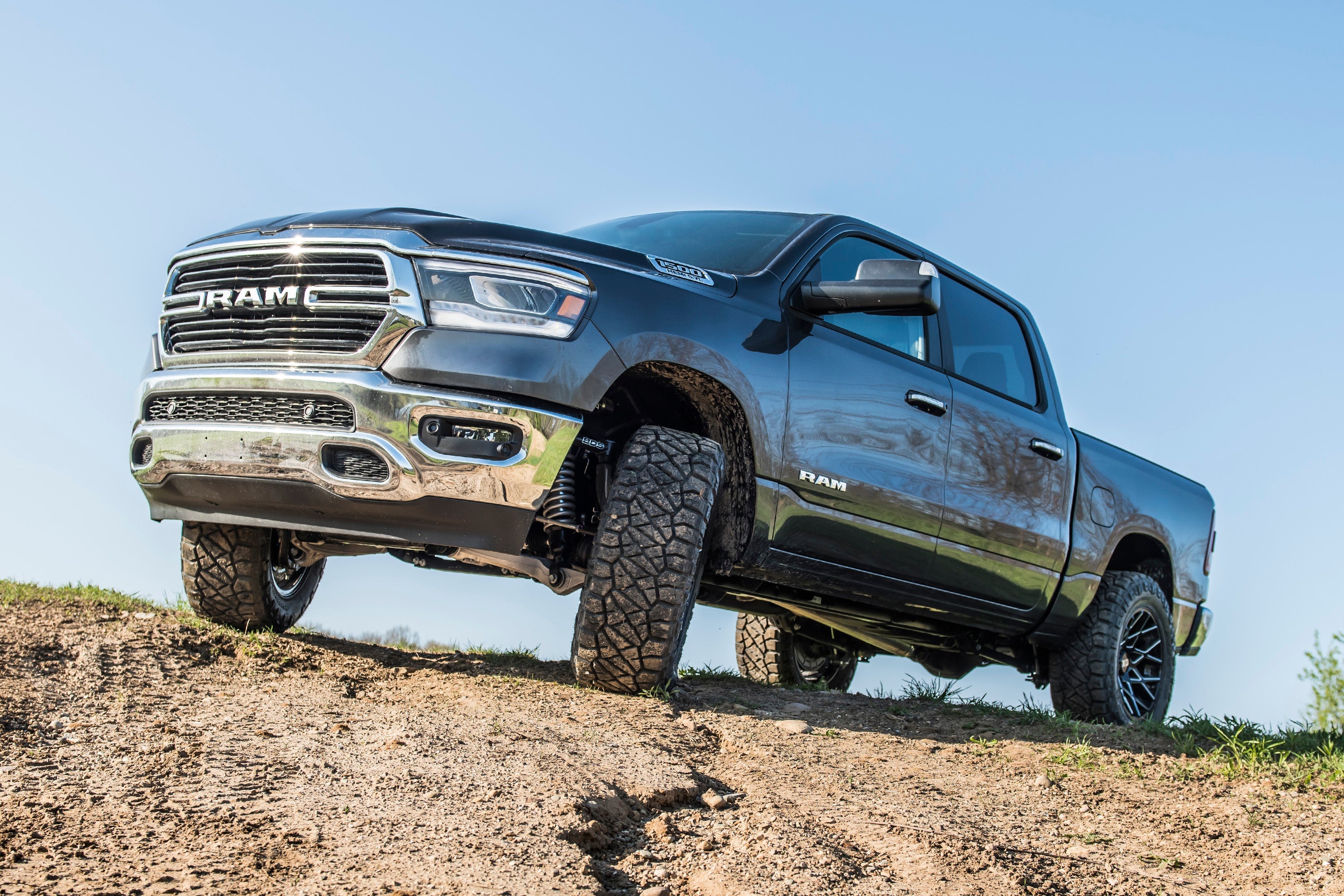Ram 1500 4WD truck equipped with a 2-inch leveling kit and FOX 2.5 Performance Elite Coil-Over, off-roading on rugged terrain.