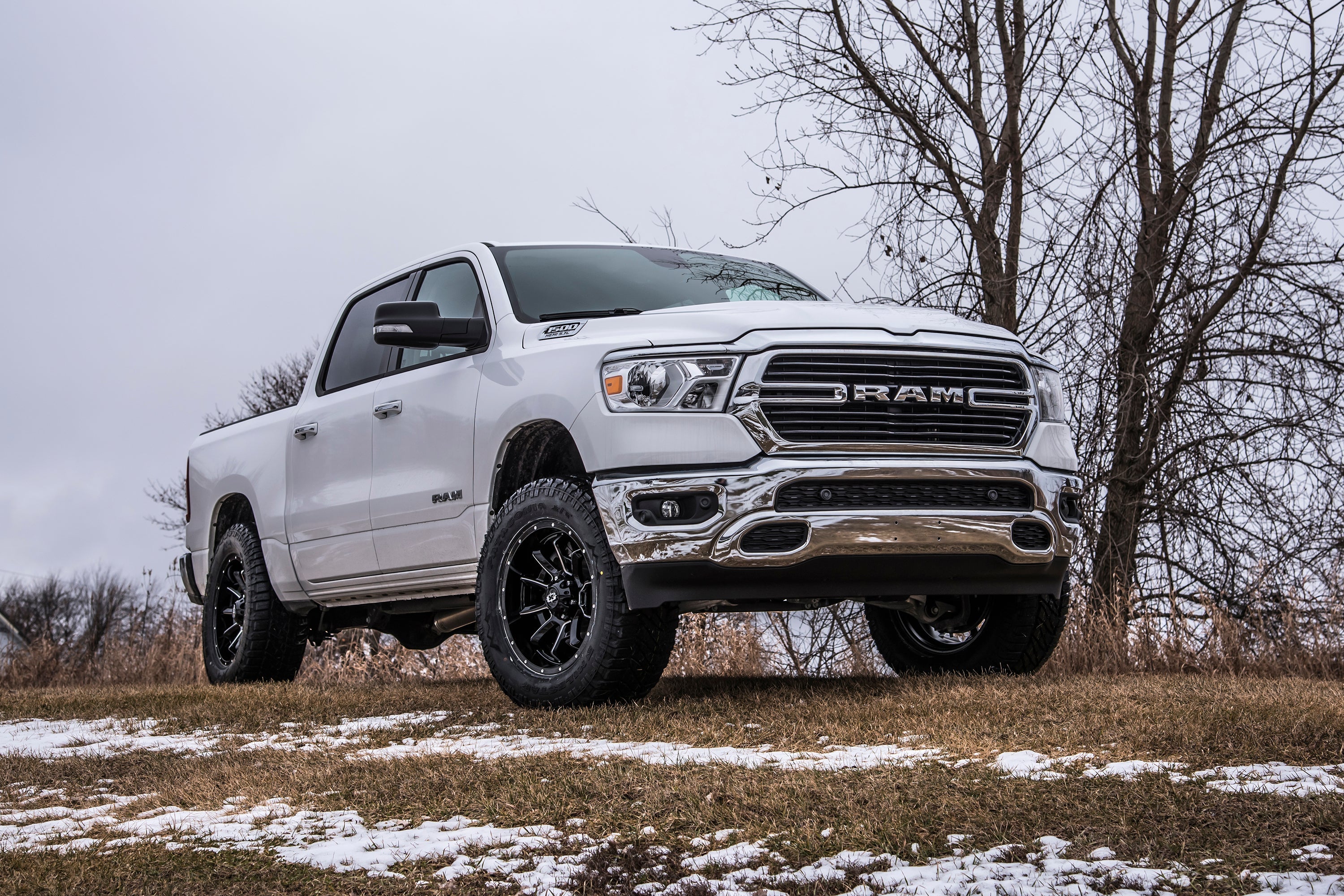 3 inch lift kit with FOX 2.5 Performance Elite Coil-Over installed on a lifted Ram 1500 Rebel parked on snowy grass.
