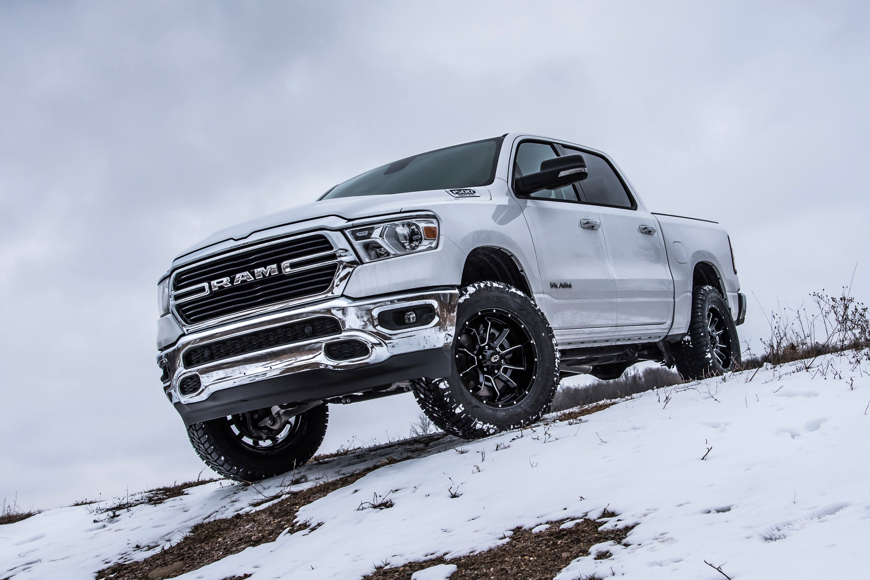 Ram 1500 Rebel with a 3-inch lift kit and FOX 2.5 coil-over suspension on a snowy hillside.