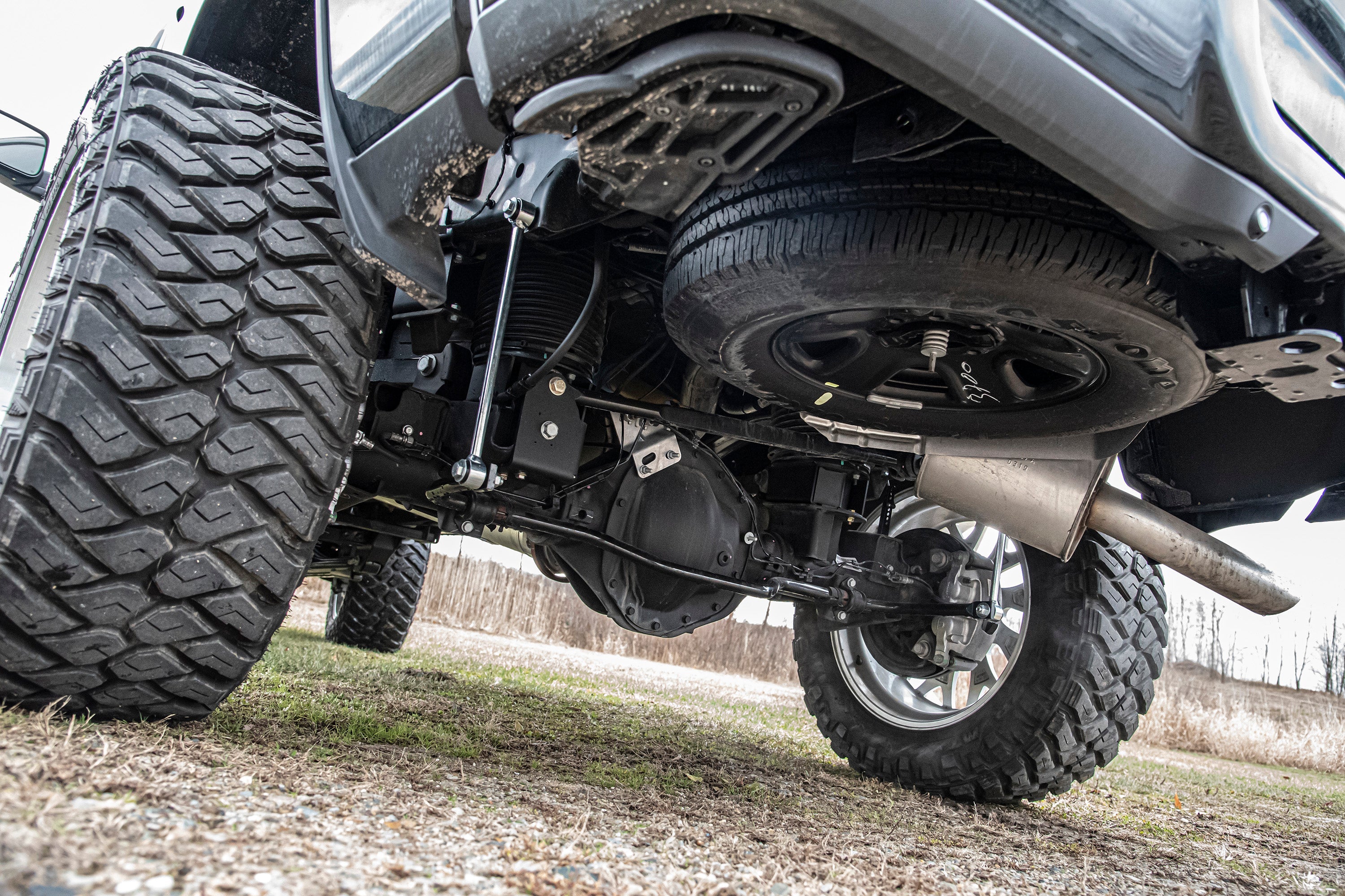 4-inch lift kit with 4-link system installed on a Ram 2500 with rear air ride, showcasing undercarriage and suspension components.