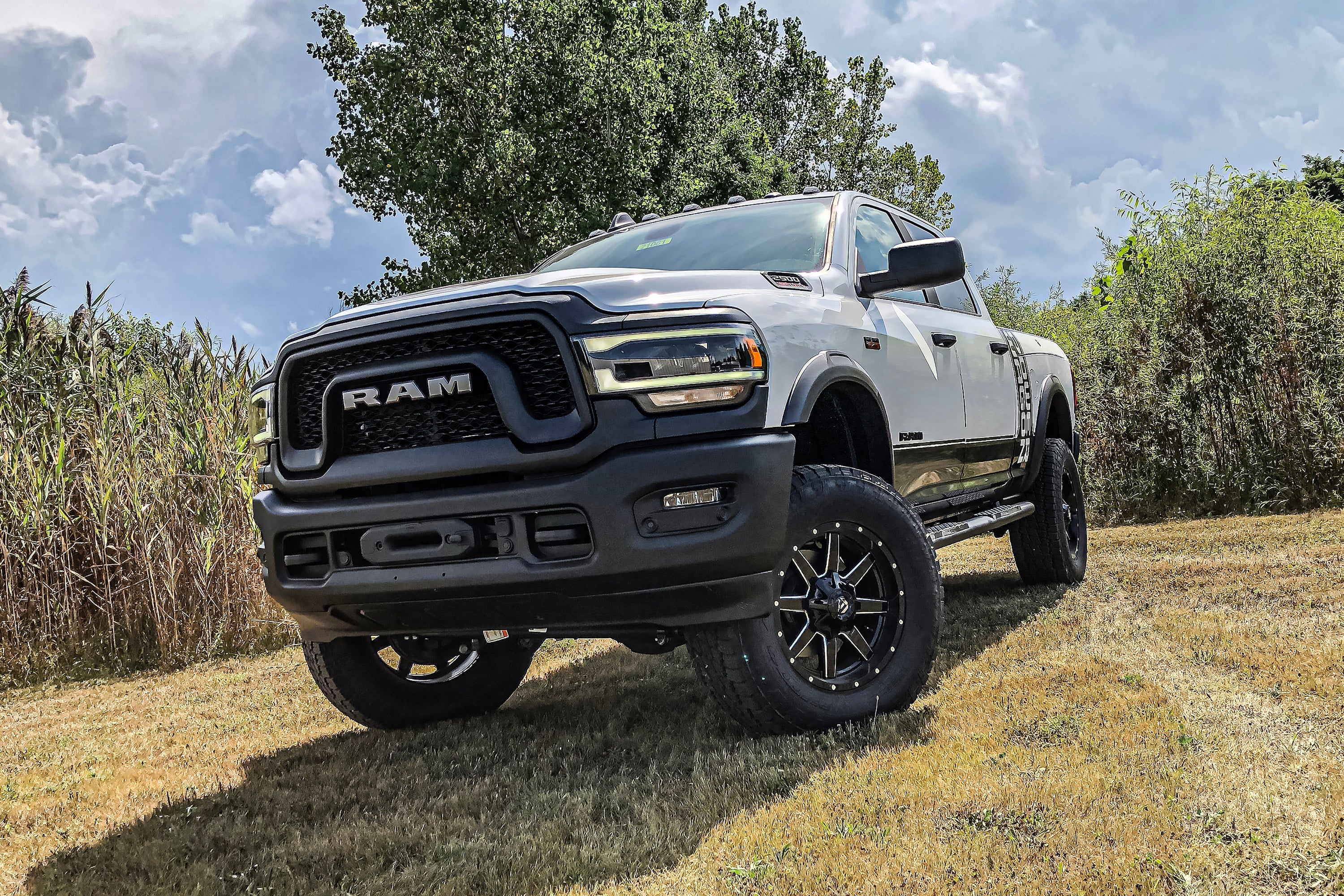2 inch lift kit for Ram 2500 Power Wagon (14-24) 4WD installed on a lifted truck in a grassy field.