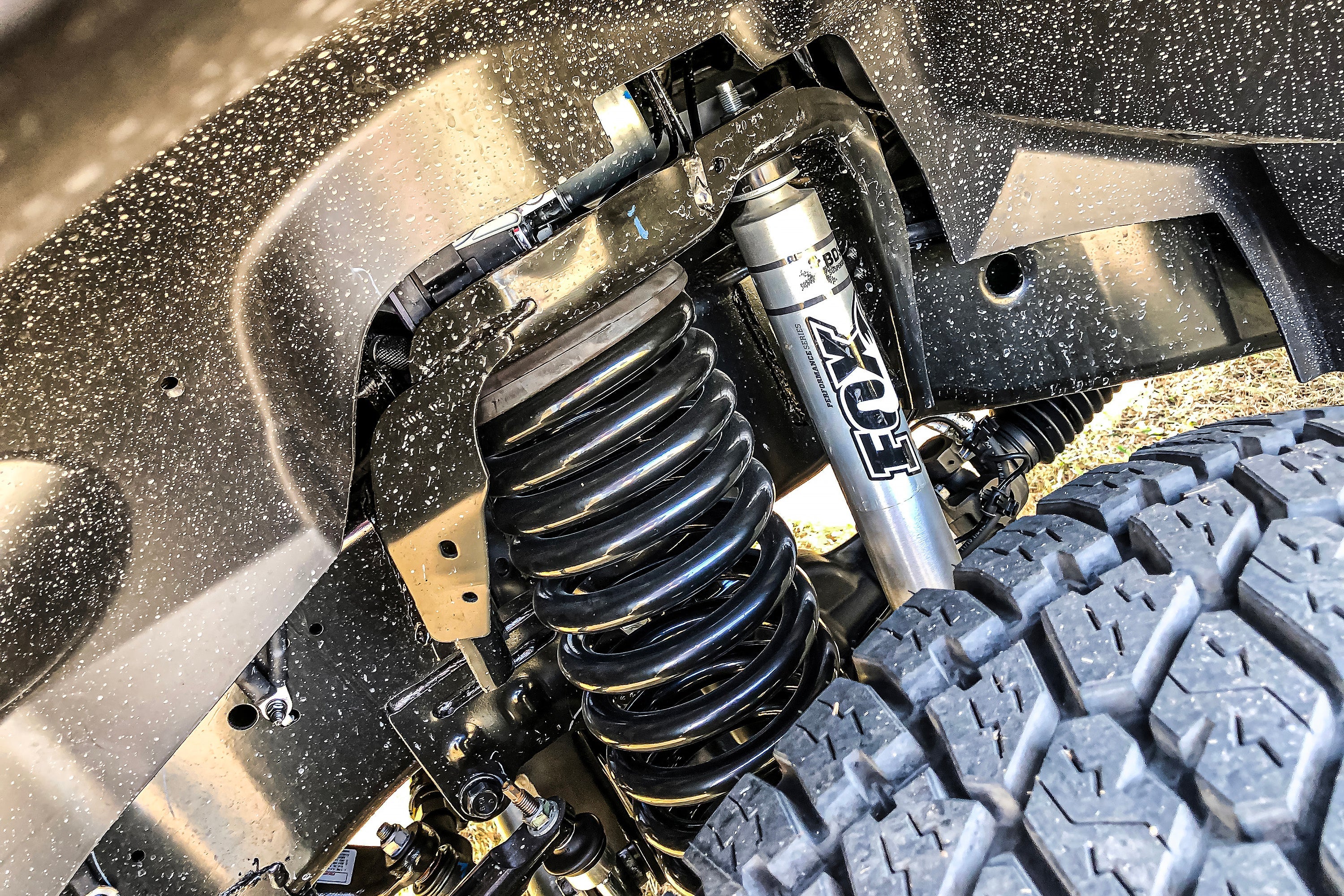 Close-up of a 2-inch lift kit installed on a Ram 2500 Power Wagon, showcasing the suspension components and shock absorber.