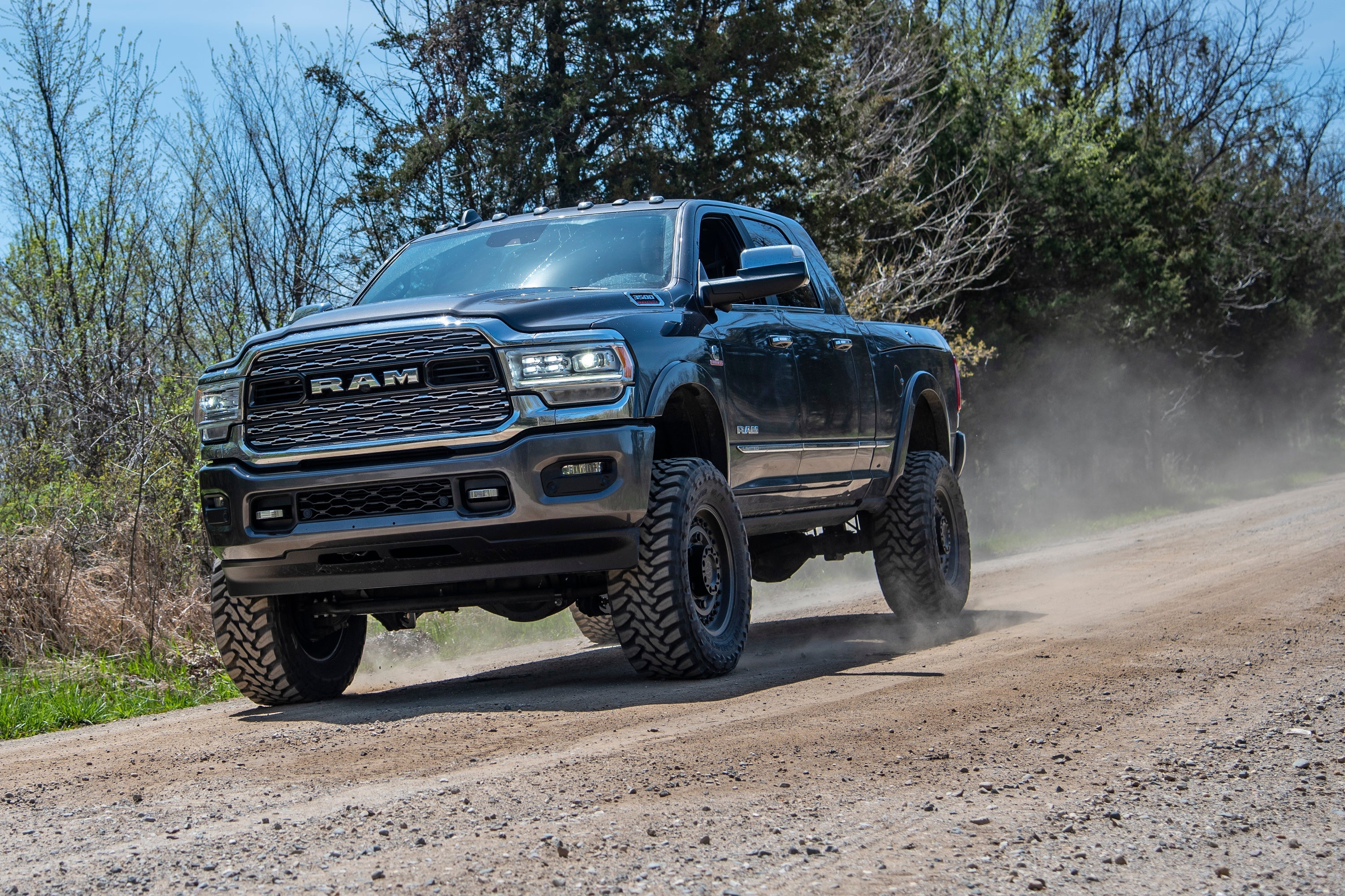 5.5 inch lift kit installed on a Ram 3500 with rear air ride, showcasing off-road capability on a dirt road.
