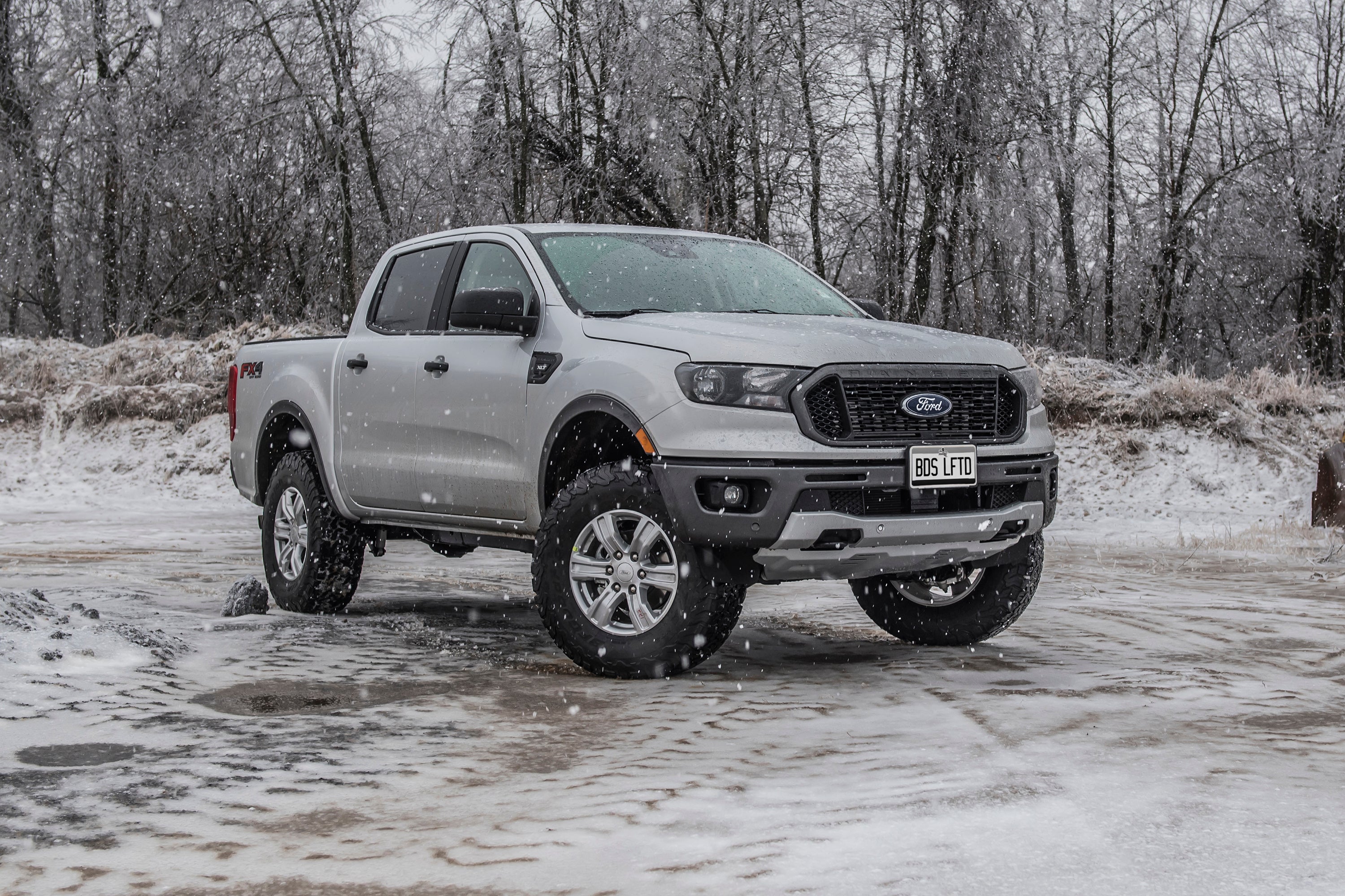 Ford Ranger 4WD with a 2.5-inch leveling kit, showcasing enhanced stance in a snowy outdoor setting.